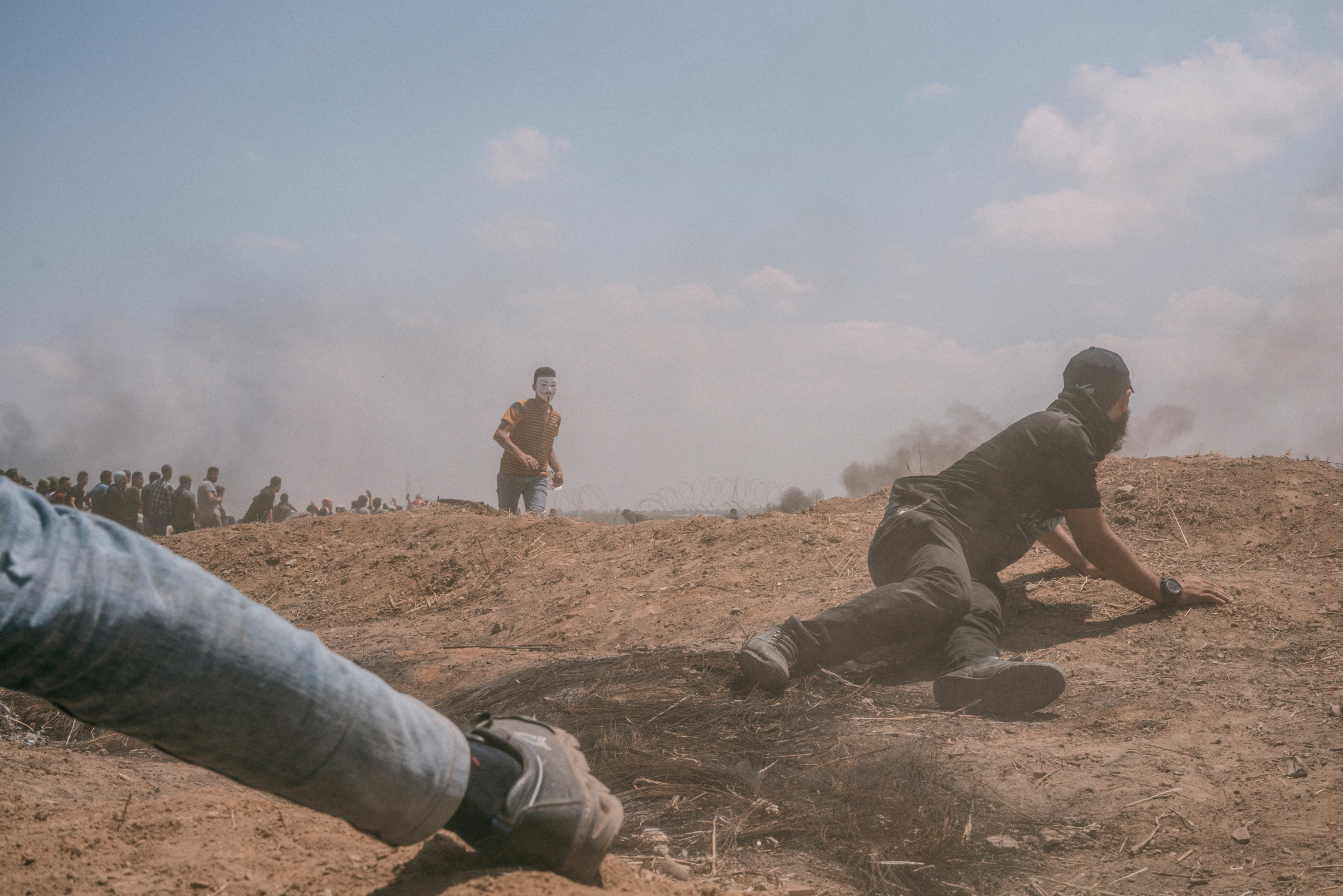 A man hides behind an embankment during the protest along the Gaza-Israel border. (Emanuele Satolli for TIME)