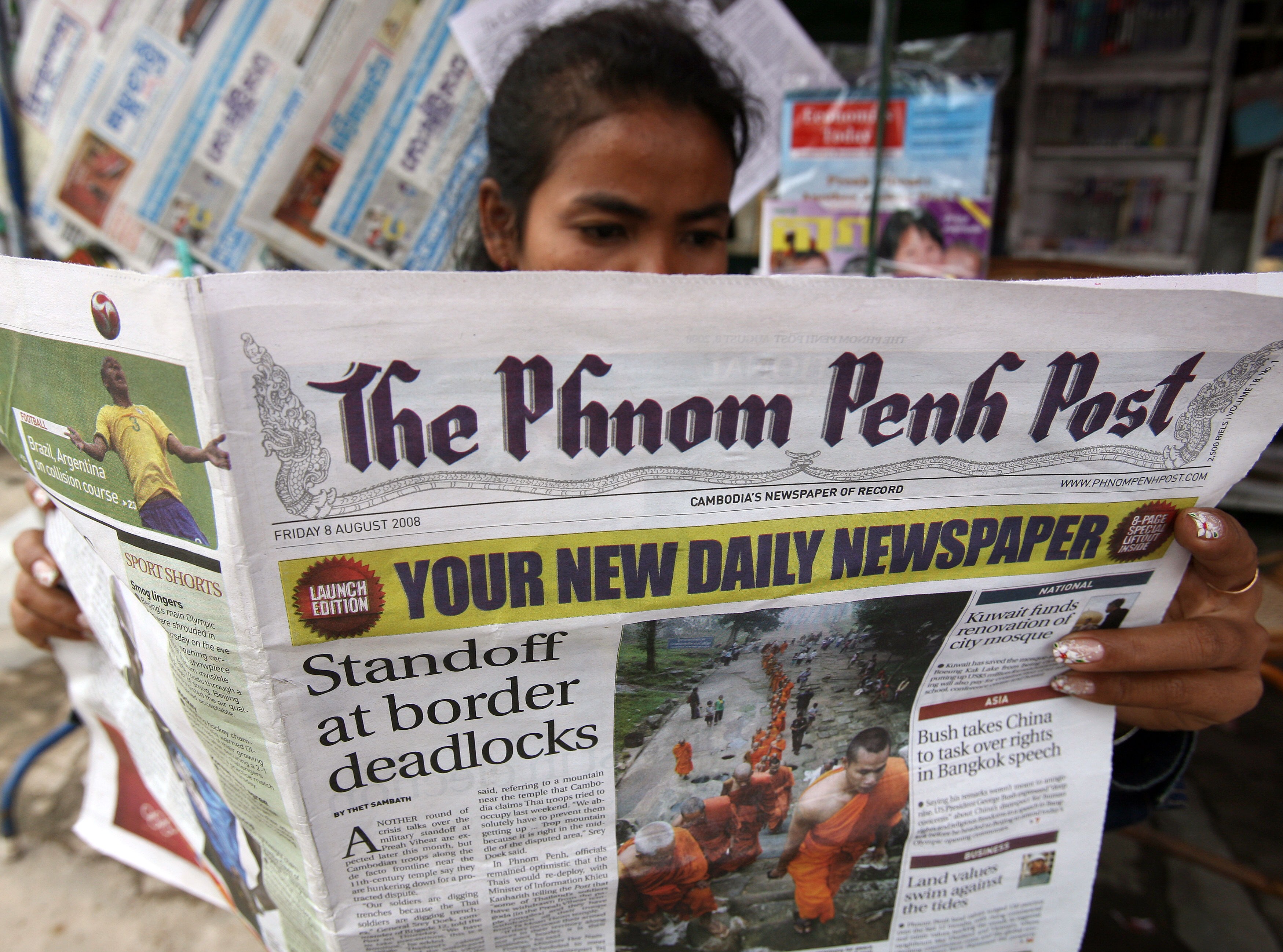 A woman reads a copy of the English-language Phnom Penh Post at a news stand in Phnom Penh, Cambodia on August 8, 2008. One of Cambodia's leading newspapers, the Post was bought by Malaysian businessman Sivakumar Ganapathy this past week, raising concerns for its editorial freedom. (Tang Chhin Sothy—AFP/Getty Images)