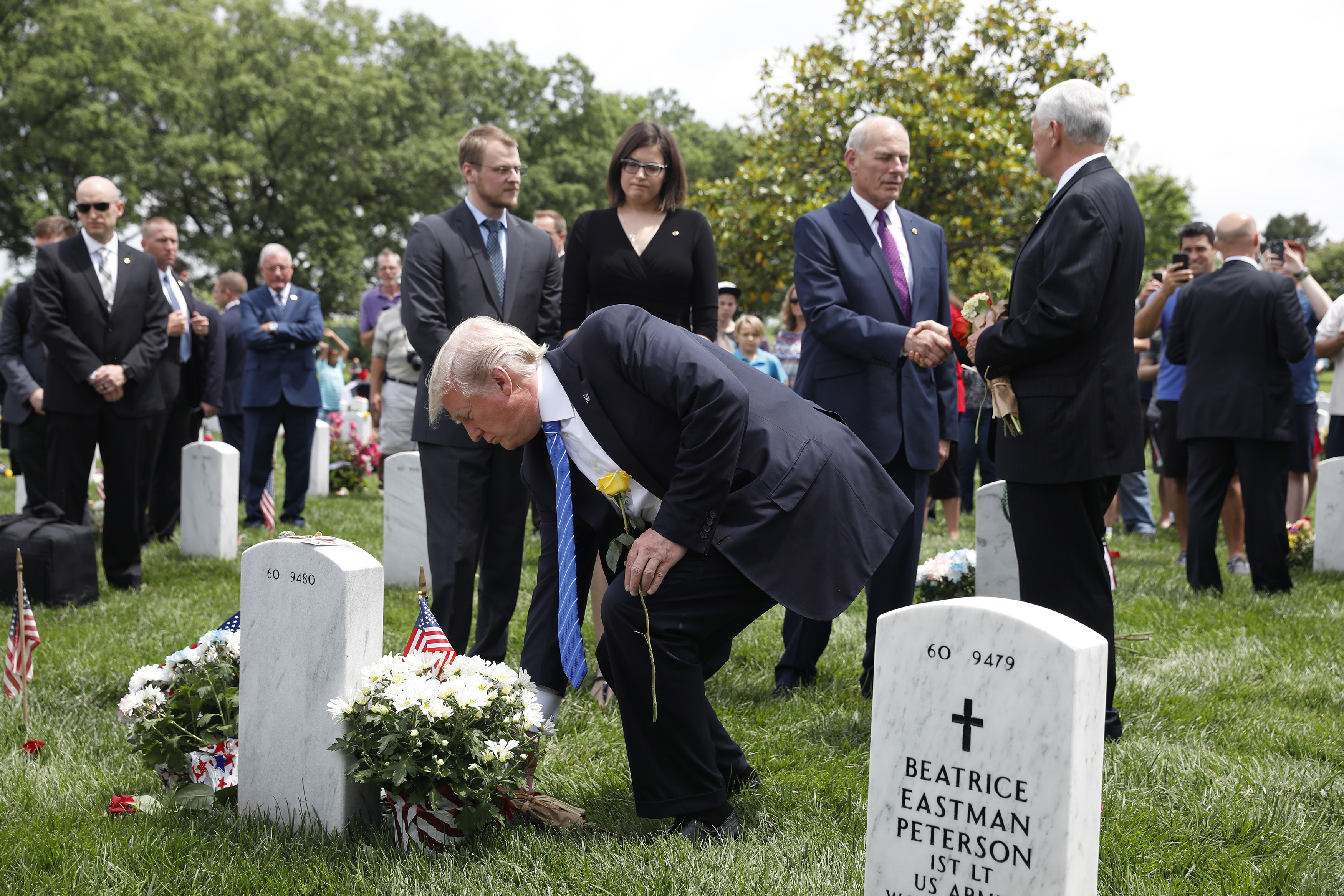 As Vice President Mike Pence and White House Chief of Staff John Kelly shake hands, President Donald Trump lays flowers on the grave of Kelly's son Robert at Arlington National Cemetery on May 29, 2017 in Arlington, Virginia. Marine Lieutenant Robert Kelly was killed in 2010 while leading a patrol in Afghanistan (Aaron P. Bernstein—Getty Images)