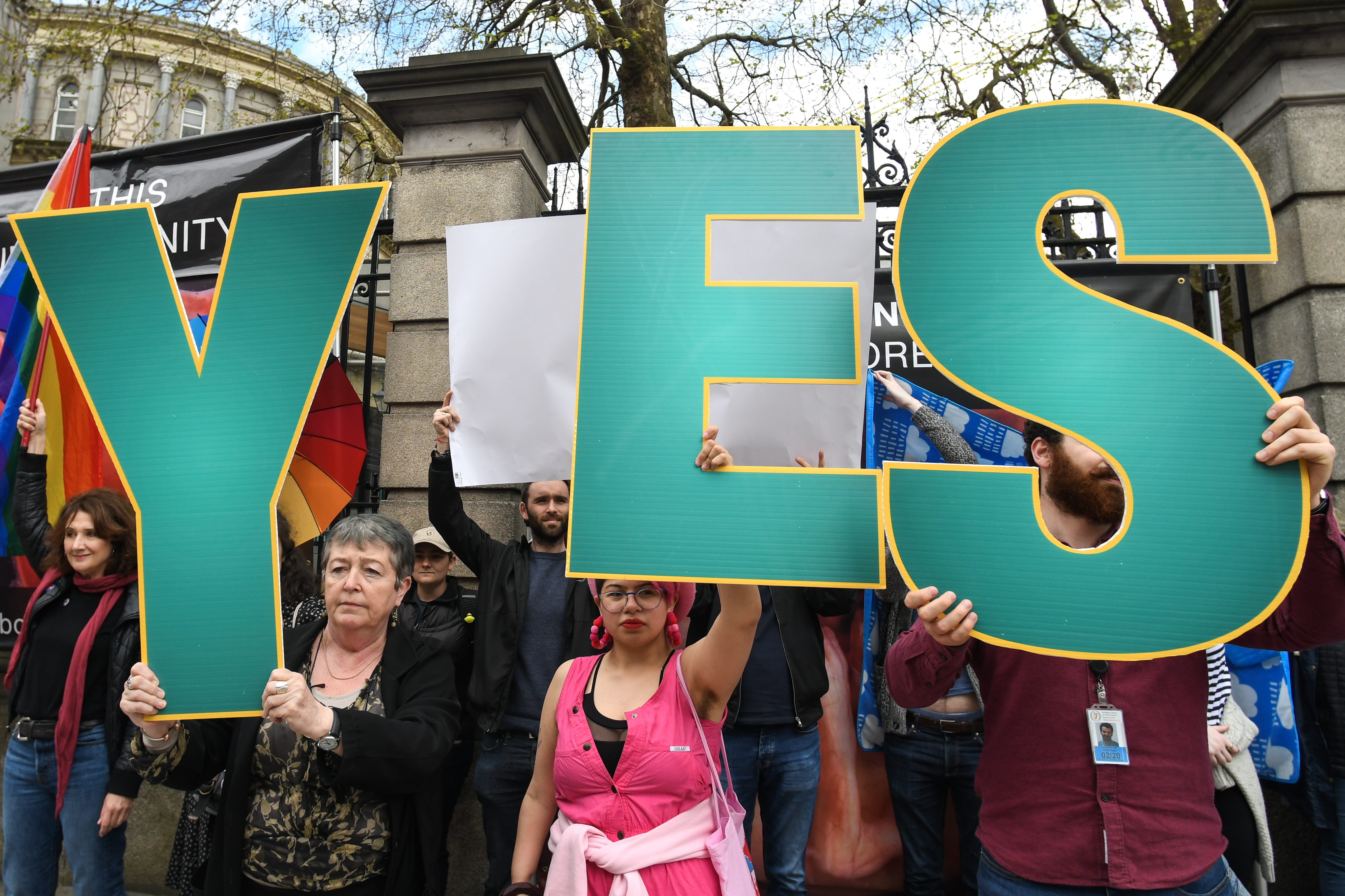 'Yes' vote campaigners cover anti-abortion group's graphic images related to pregnancy and abortion, with Irish and rainbow flags, and white billboards, outside Leinster House, the Irish Parliament, on Friday, May 4, 2018, in Dublin, Ireland. (Artur Widak—NurPhoto via Getty Images)