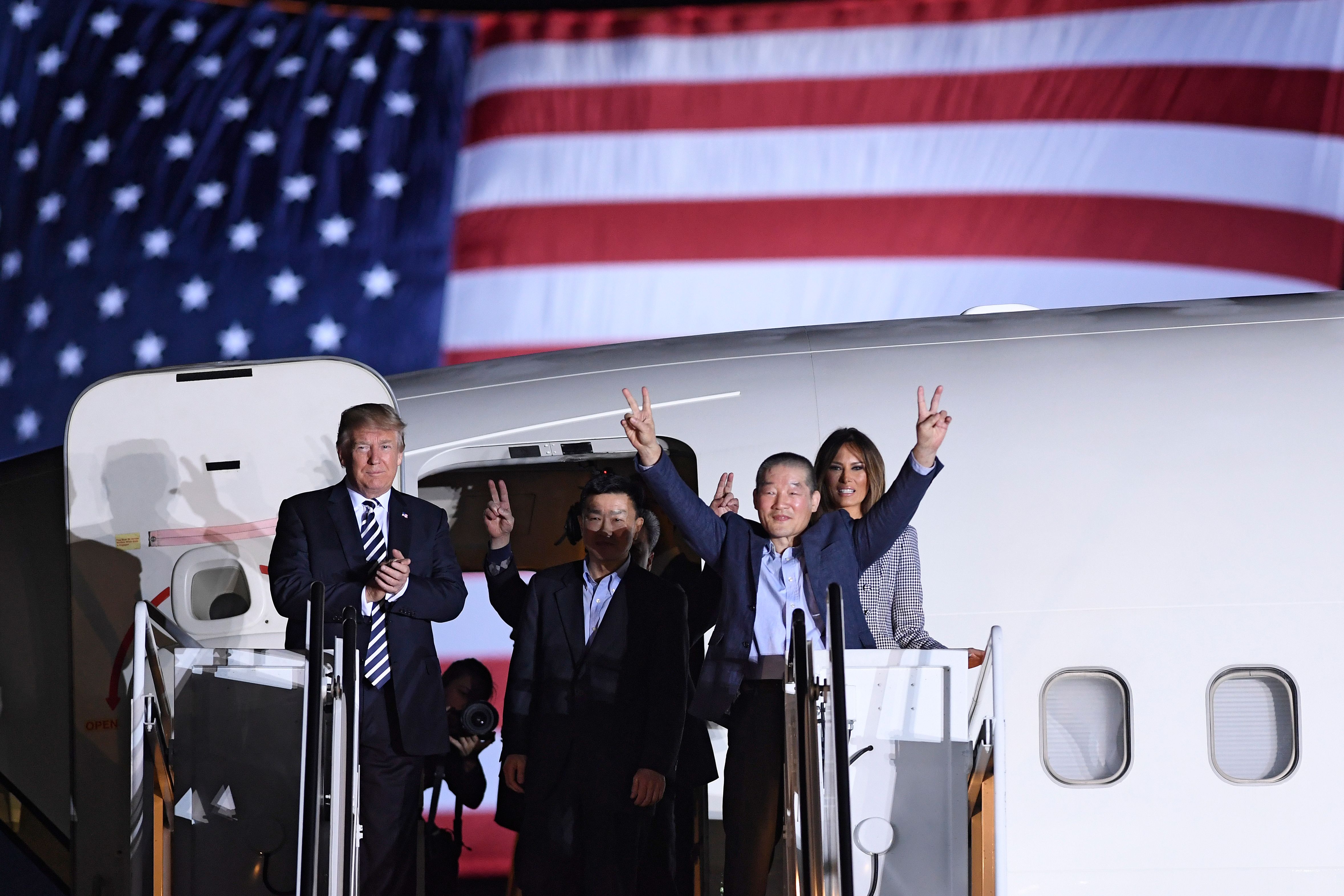 President Donald Trump applauds as Kim Dong-chul gestures upon his return with Kim Hak-song and Tony Kim after they were freed by North Korea, at Joint Base Andrews in Maryland on May 10, 2018. (Saul LoebA—AFP/Getty Images)