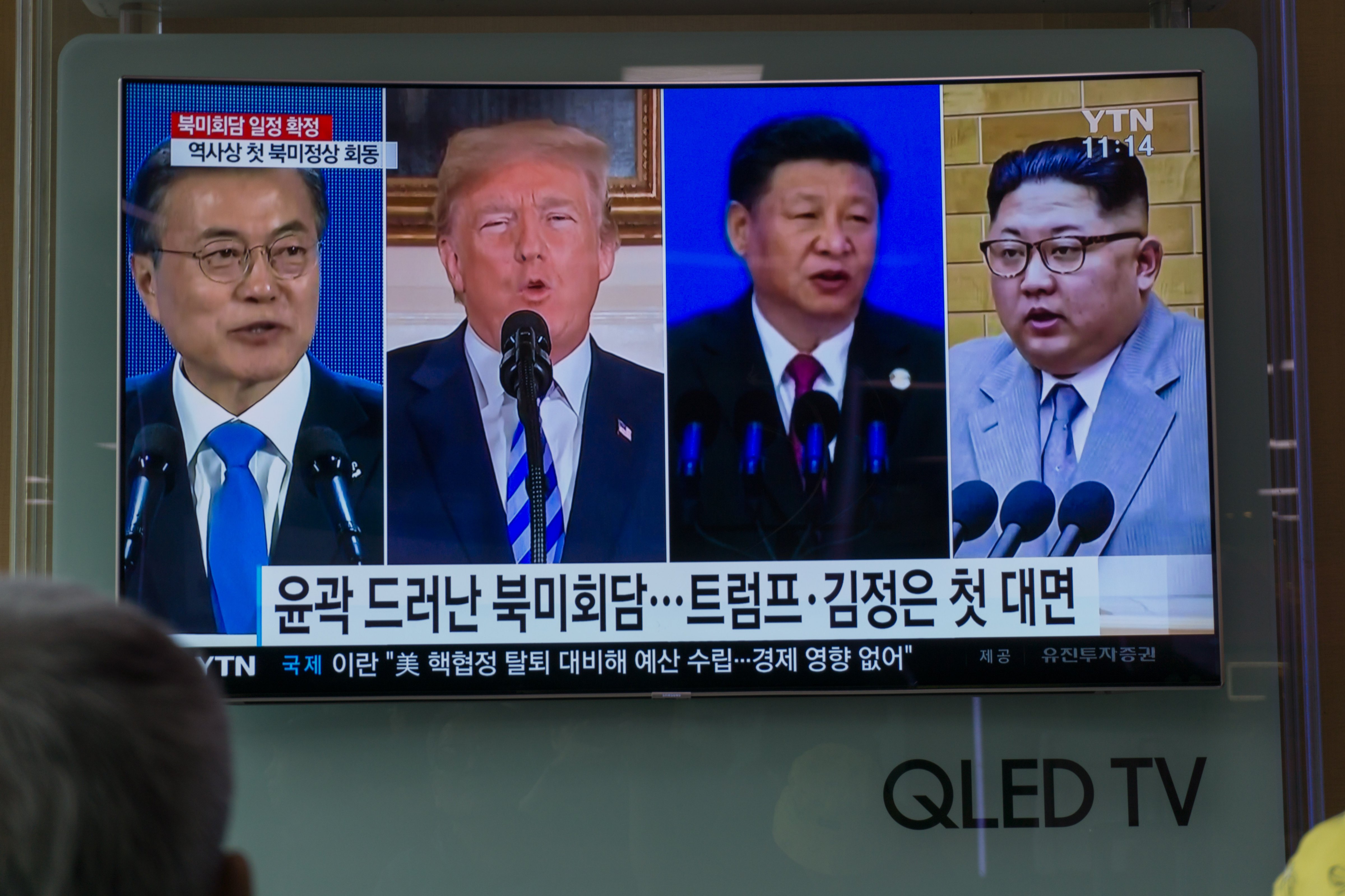 People watch a screen showing images of South Korea's president Moon Jae-in, U.S. president Donald Trump, China's president Xi Jinping, and North Korea's leader Kim Jong Un at a railway station in Seoul on May 11, 2018. (Kim Sue-Han—AFP/Getty Images)