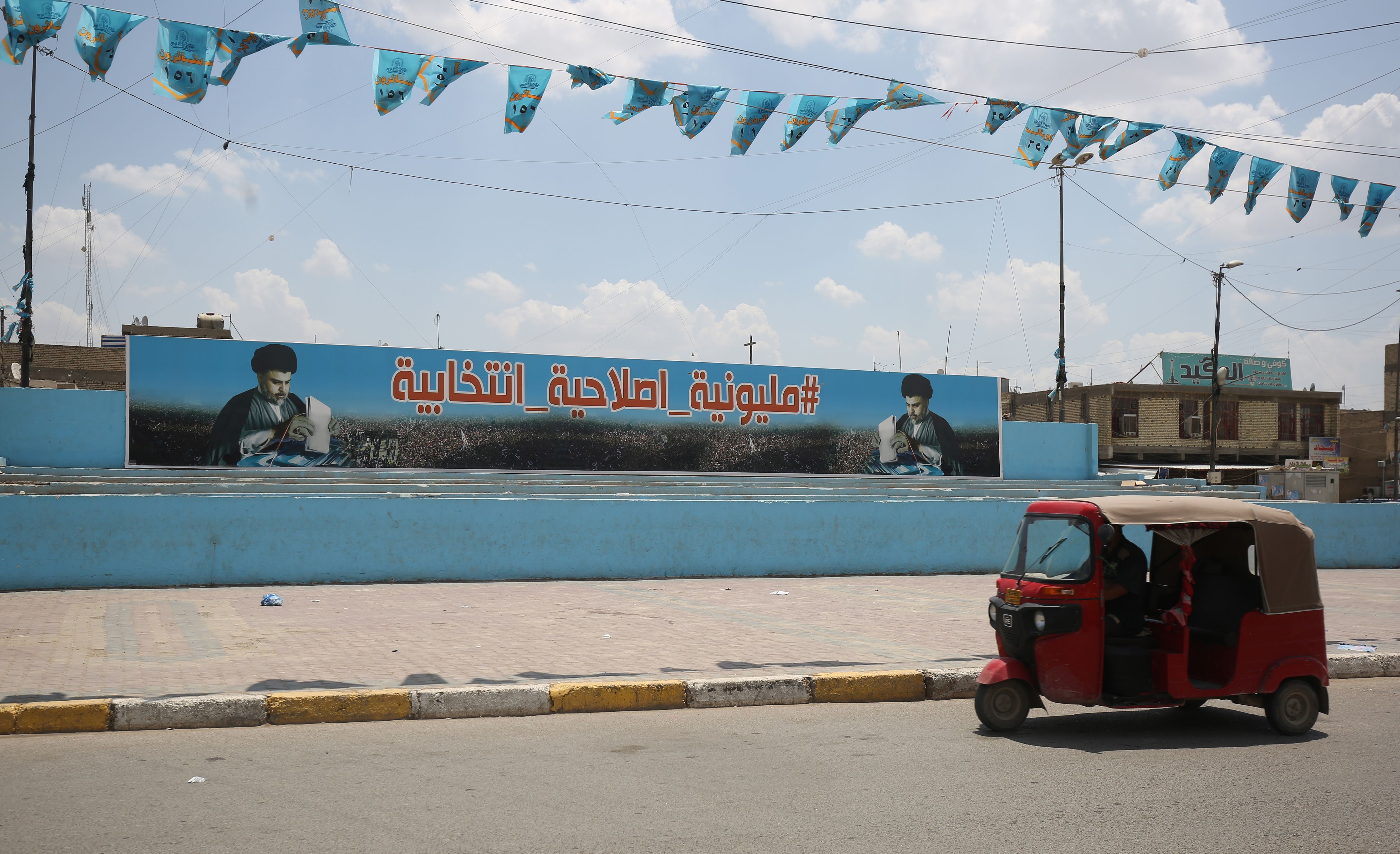 A small vehicle drives past a poster of Shiite leader Muqtada al-Sadr in Sadr City, east of the Iraqi capital Baghdad on May 14, 2018. (AHMAD AL-RUBAYE—AFP/Getty Images)