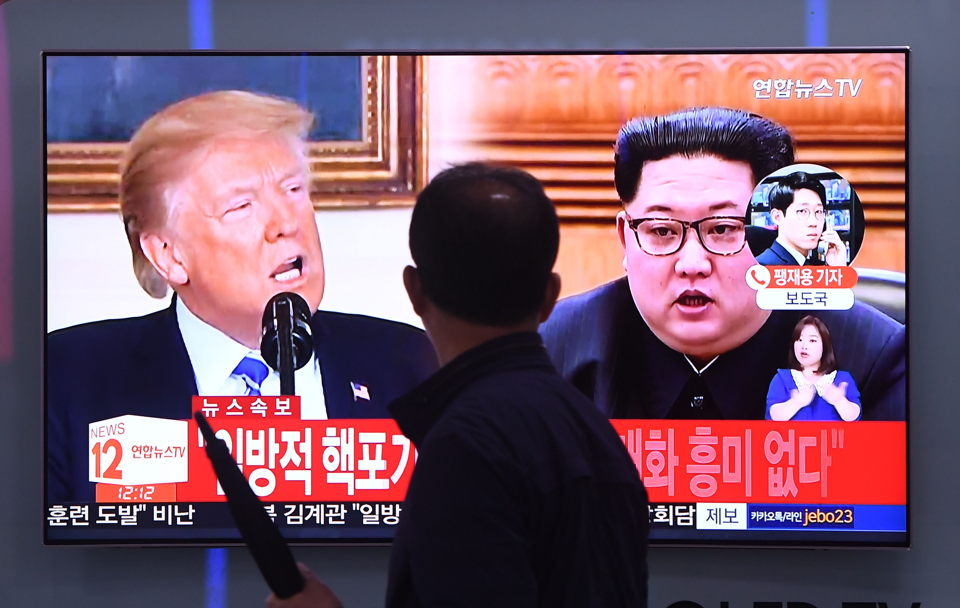 A man walks past a television news screen showing North Korean leader Kim Jong Un (R) and US President Donald Trump (L) at a railway station in Seoul on May 16, 2018. (JUNG YEON-JE—AFP/Getty Images)