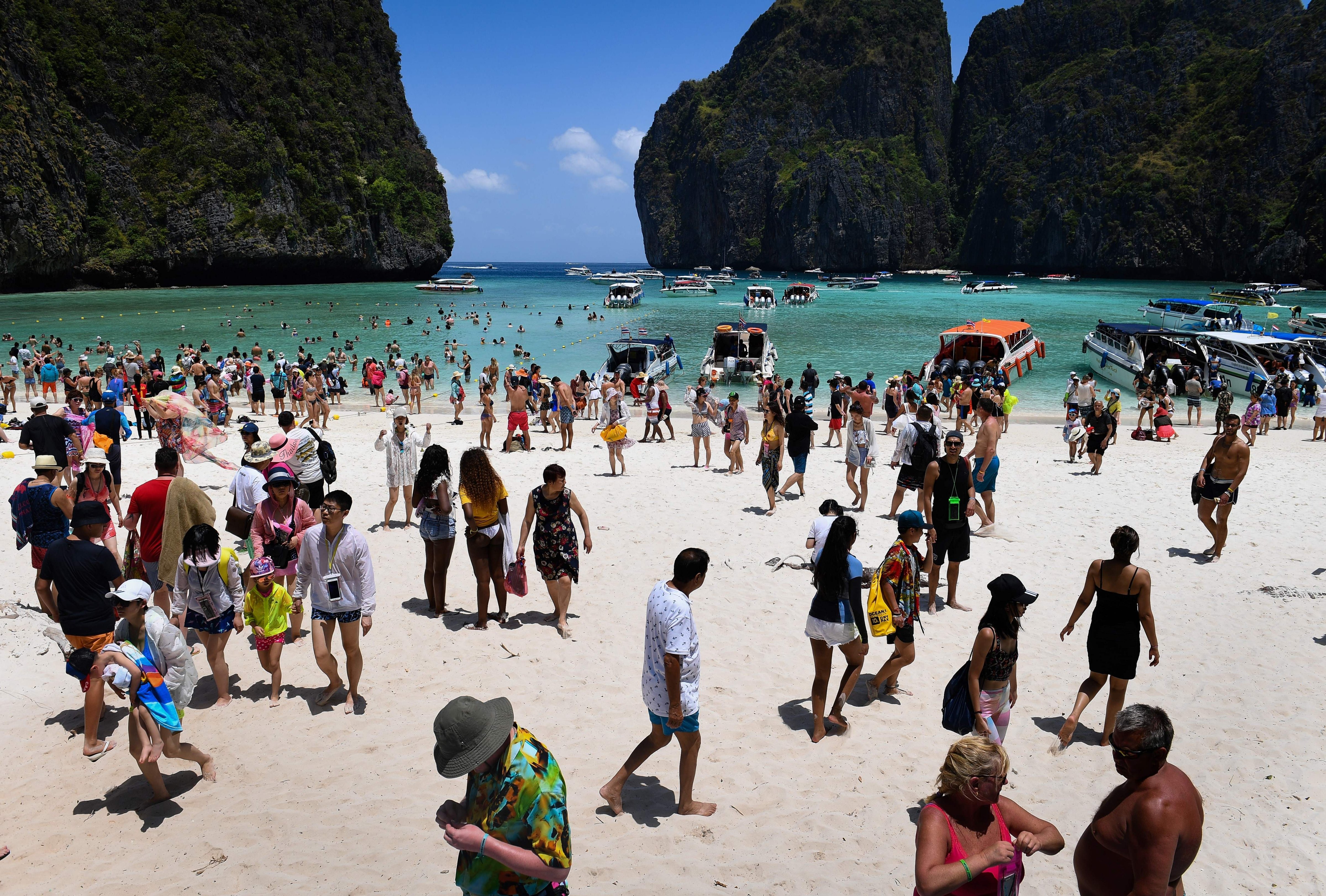 This photo taken on April 9, 2018 shows a crowd of tourists on the Maya Bay beach, on the southern Thai island of Koh Phi Phi.  
                      Across the region, Southeast Asia's once-pristine beaches are reeling from decades of unchecked tourism as governments scramble to confront trash-filled waters and environmental degradation without puncturing a key economic driver. (LILLIAN SUWANRUMPHA&mdash;AFP/Getty Images)