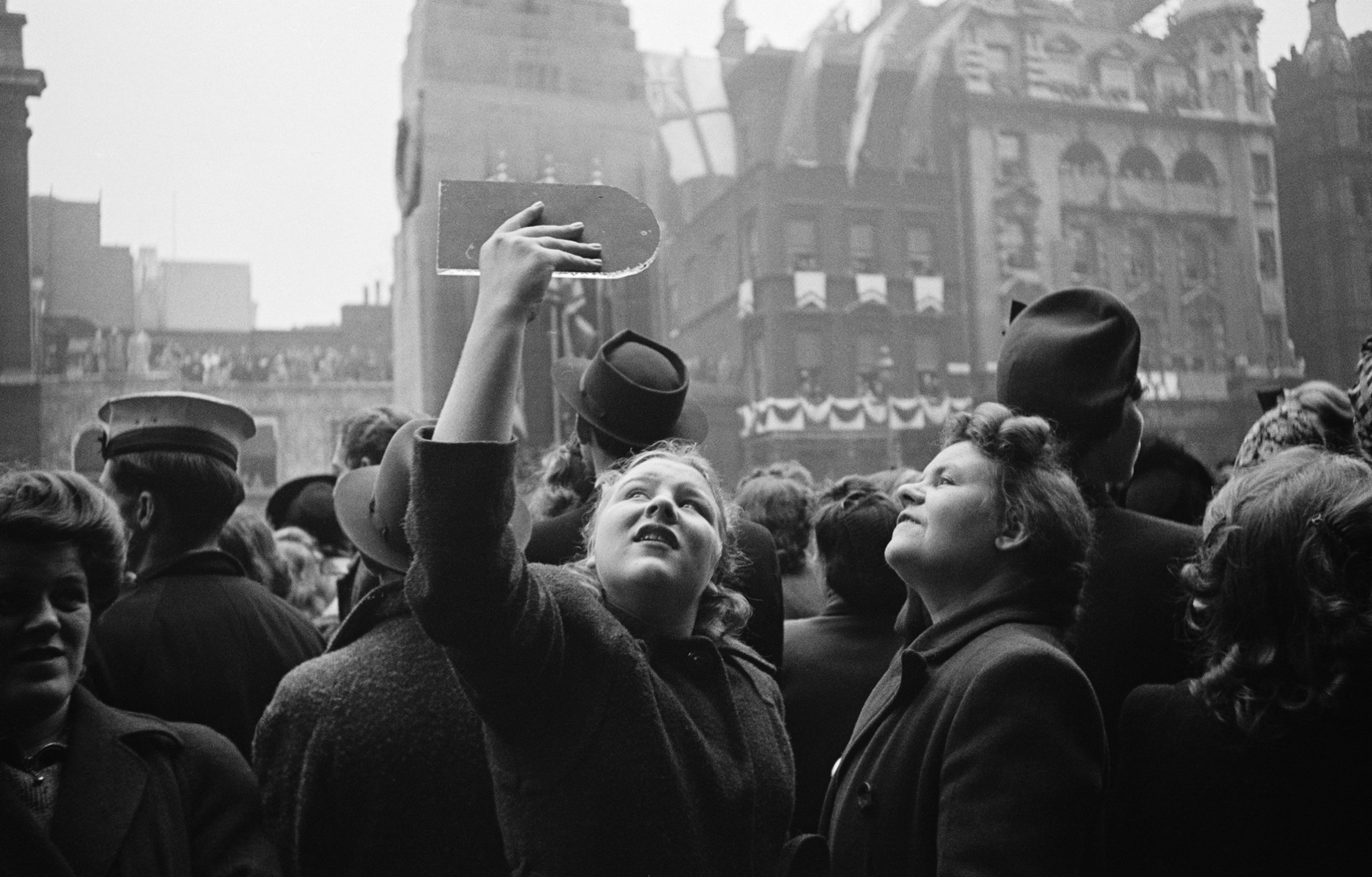 Spectators use hand-held mirrors to see over the crowd during the wedding of Queen Elizabeth II and Prince Philip, Duke of Edinburgh, at Westminster Abbey in London, Nov. 20, 1947.