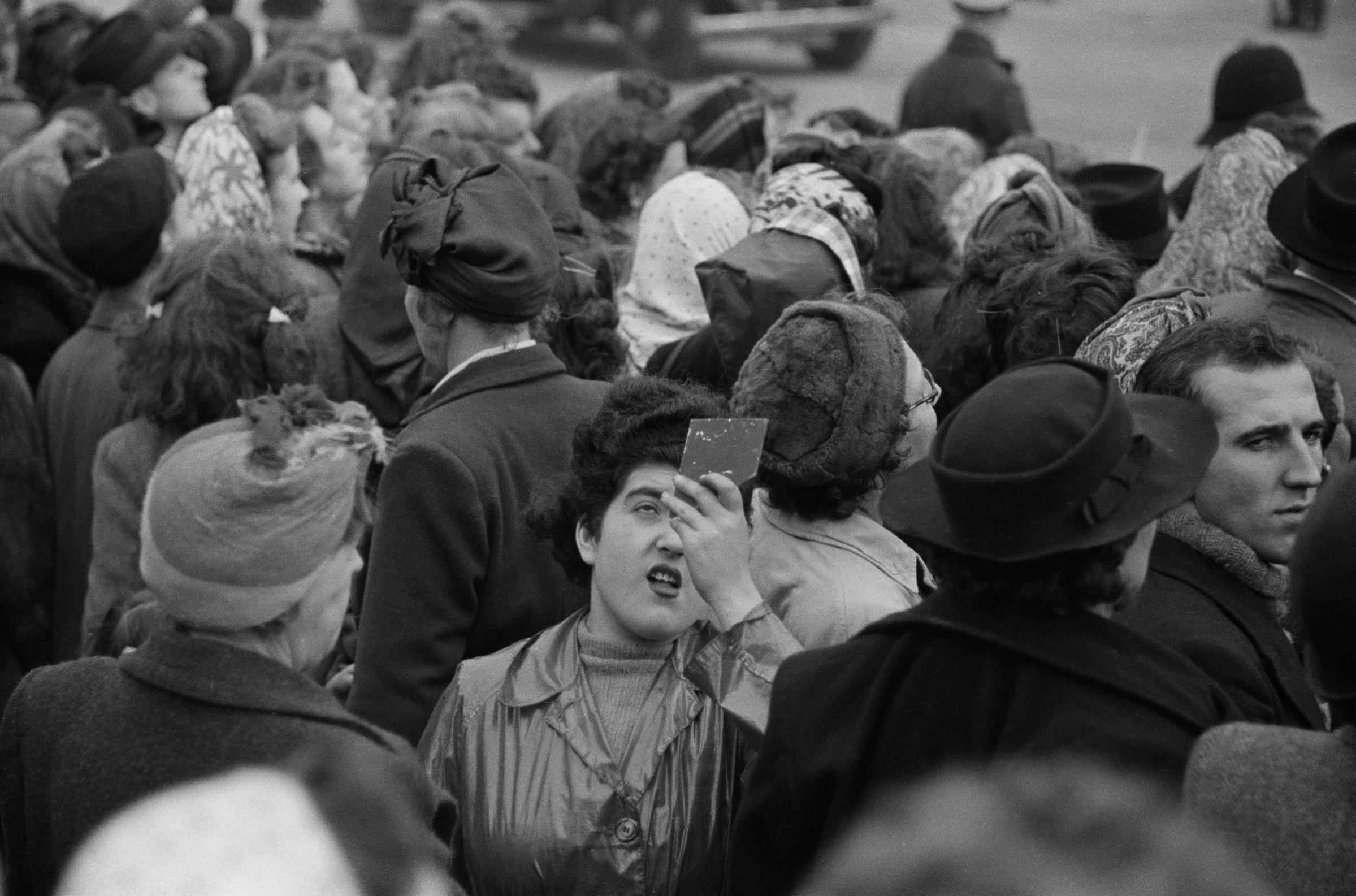 A spectator uses a hand-held mirror to see over the crowd during the wedding of Queen Elizabeth II and Prince Philip, Duke of Edinburgh, Nov. 20, 1947.