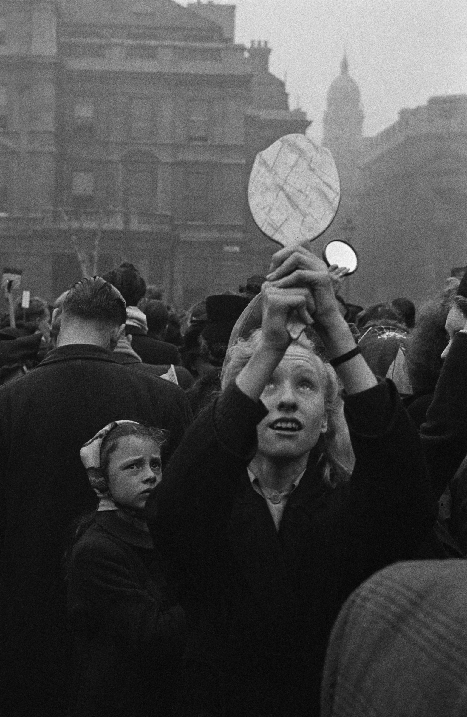 A spectator uses a hand-held mirror to see over the crowd during the wedding of Queen Elizabeth II and Prince Philip, Duke of Edinburgh, Nov. 20, 1947.