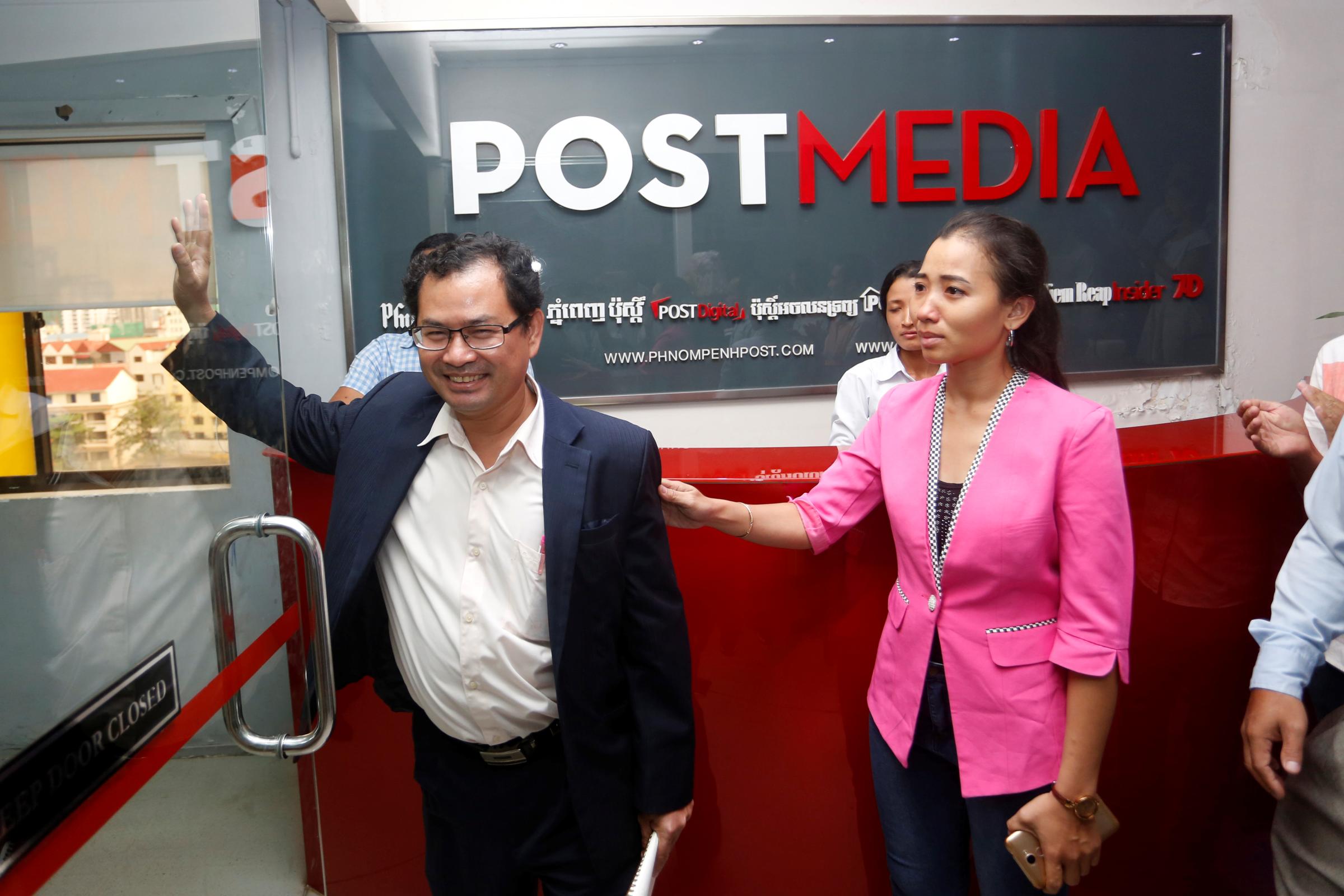 Editor-in-Chief Kay Kimsong wavs as he walks out after being fired from the Phnom Penh Post newspaper