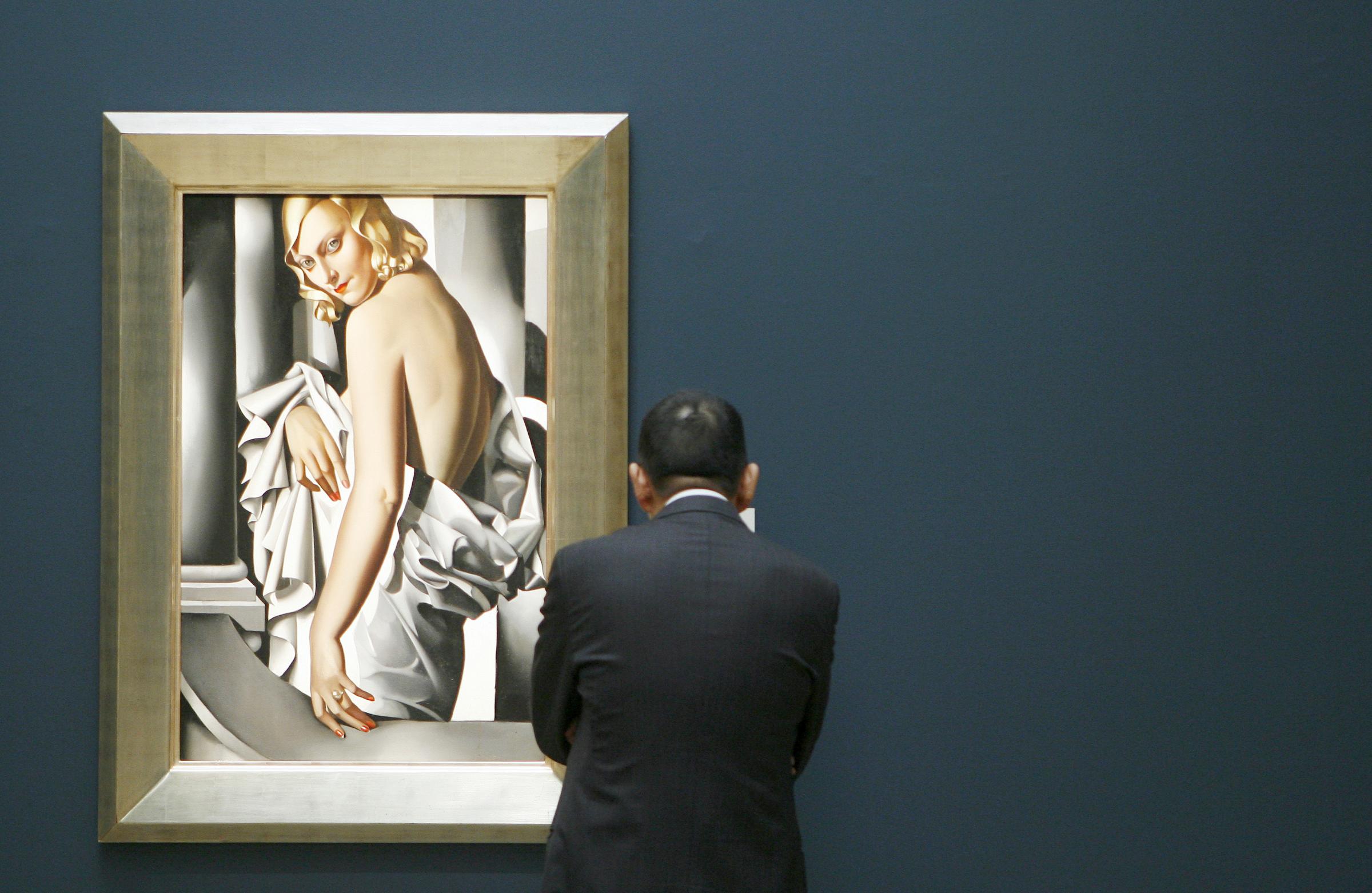 A man takes a look at Tamara de Lempicka's "Portrait de Majorie Ferry" at Sotheby's in New York