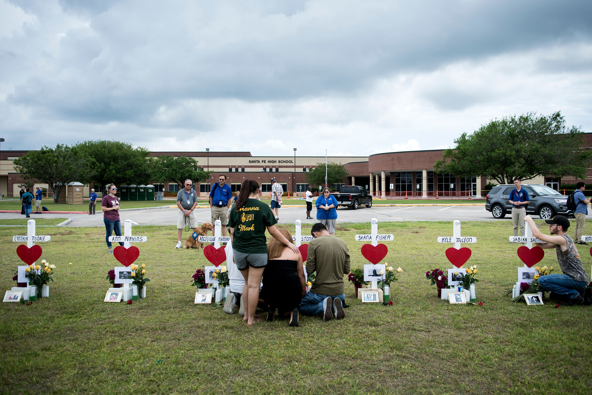 People visit a cross for Christopher Stone at a memorial for the victims of the Santa Fe High School shooting on May 21, 2018 in Santa Fe, Texas. (Brendan Smialowski—AFP/Getty Images)