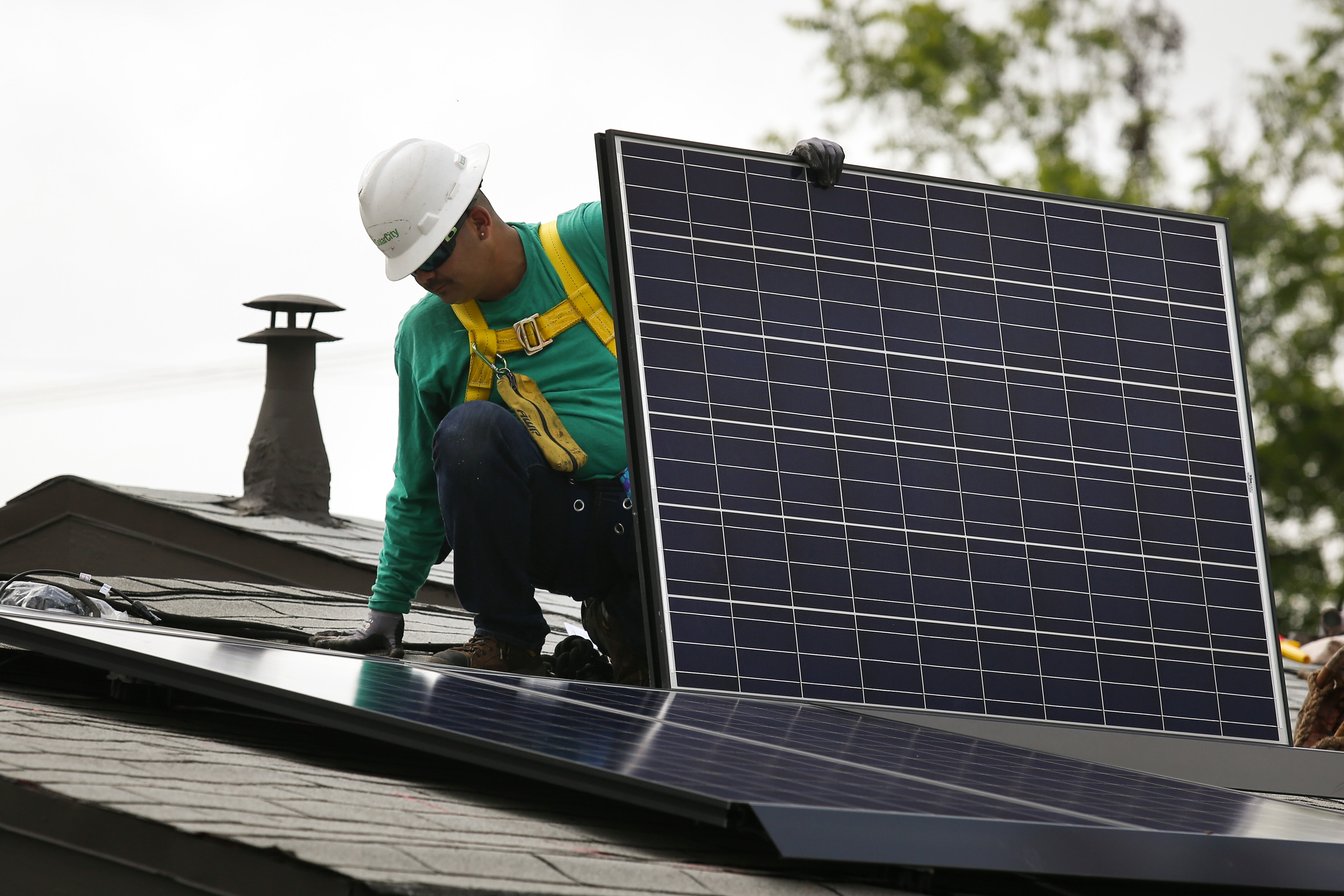 An employee installs a solar panel on the roof of a home in Los Angeles. Photographer: Patrick T. Fallon/Bloomberg via Getty Images (Bloomberg&mdash;Bloomberg via Getty Images)