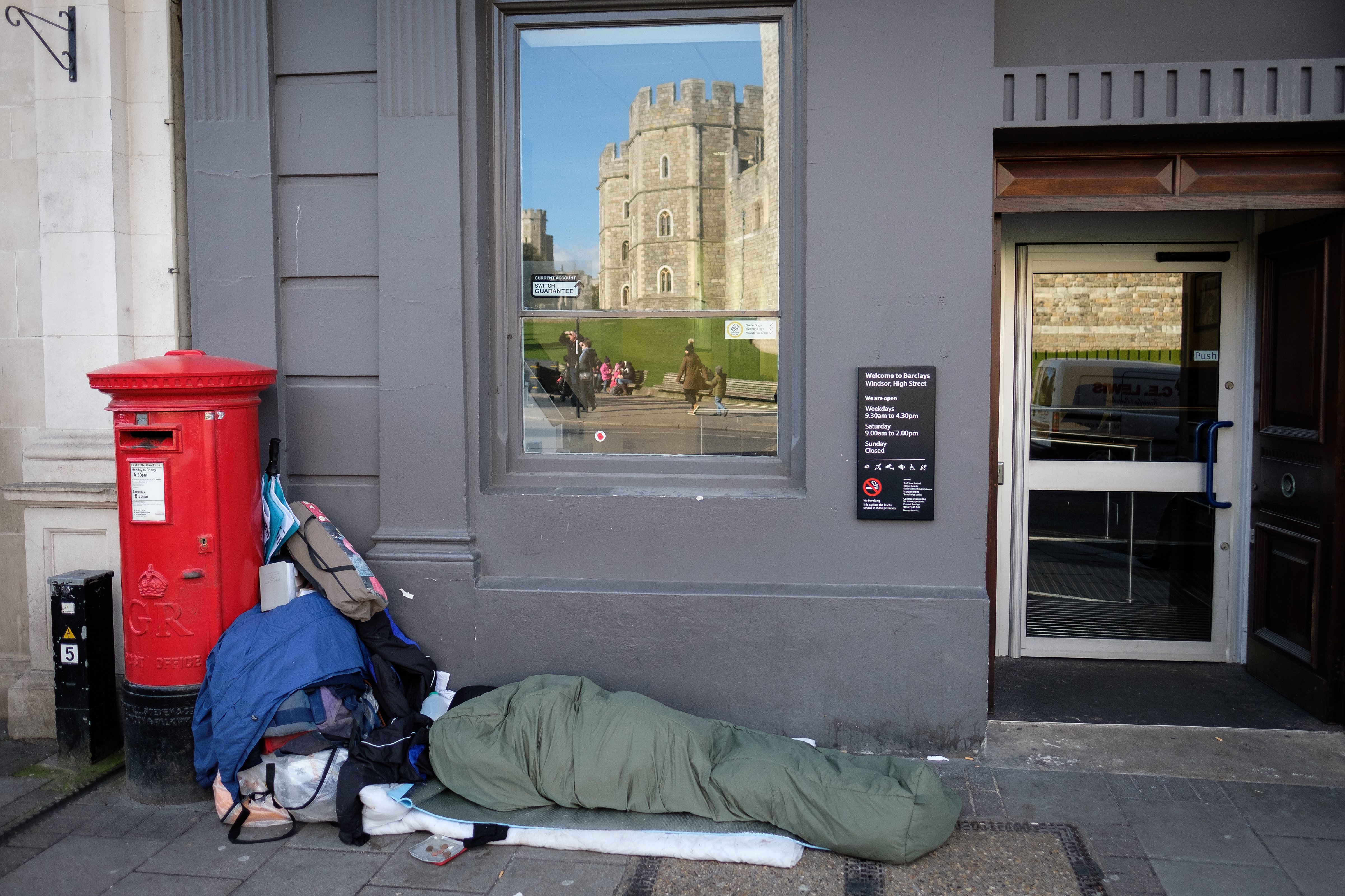 Windsor Castle is seen in the reflection of a bank window as Sunny, a homeless man who has been on the streets of Windsor for around eight months, lays in his sleeping bag on January 5, 2018 in Windsor, England. (Leon Neal&mdash;Getty Images)