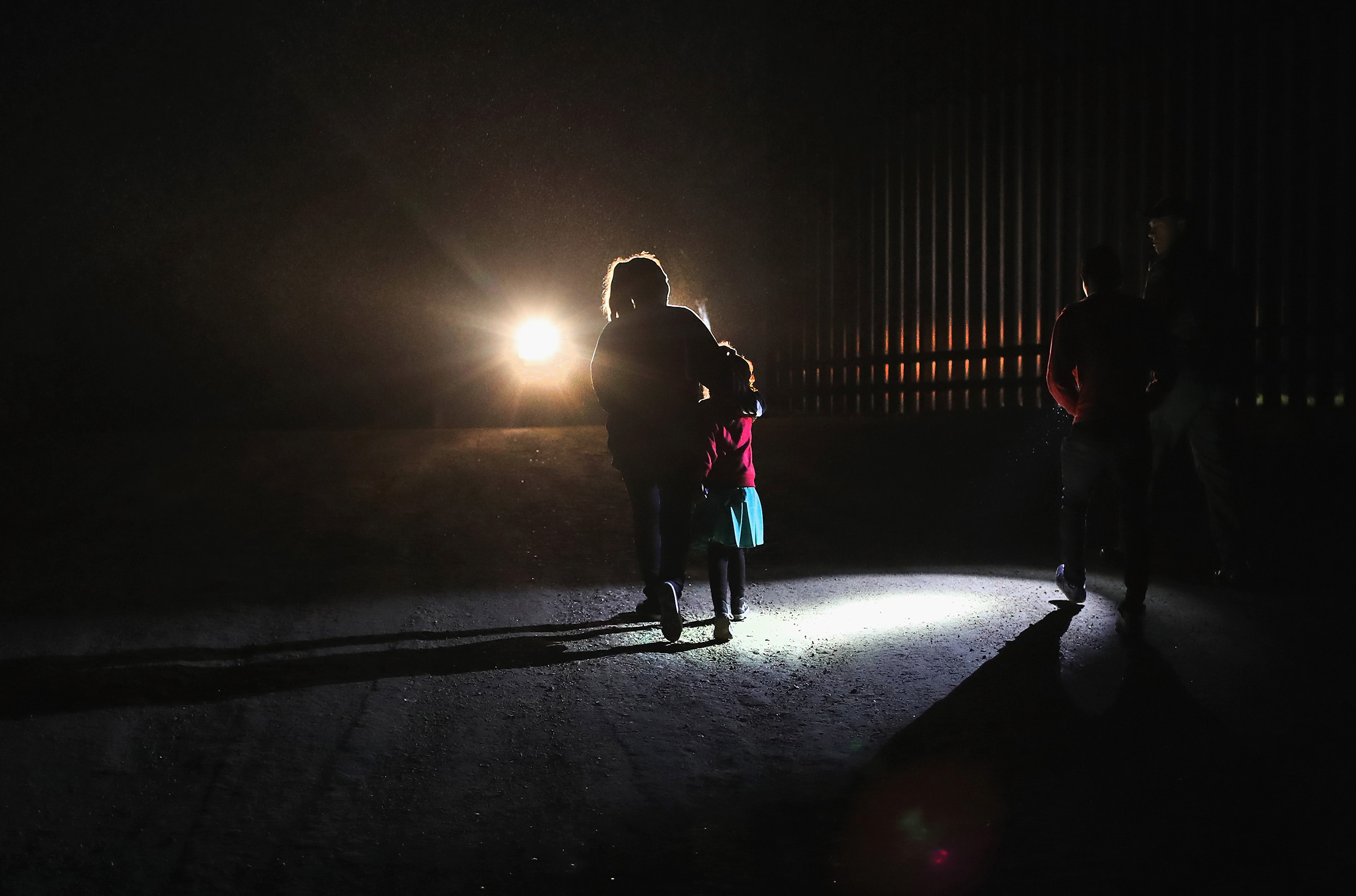 A Honduran mother walks with her children next to the U.S.-Mexico border fence as they turned themselves in to Border Patrol agents on February 22, 2018 near Penitas, Texas. Thousands of Central American families continue to enter the U.S., most seeking political asylum from violence in their home countries. The Rio Grande Valley has the highest number of undocumented immigrant crossings and narcotics smuggling of the entire U.S.-Mexico border. (John Moore—Getty Images)