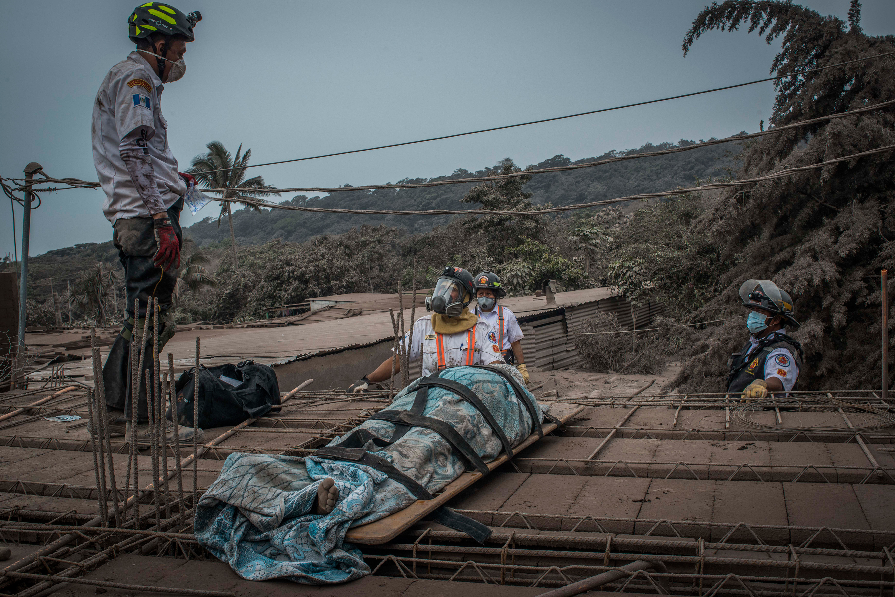 Rescuers recover a body among the ruins of the village of San Miguel Los Lotes, near the Guatemalan city of Escuintla, on June 4. (Daniele Volpe)
