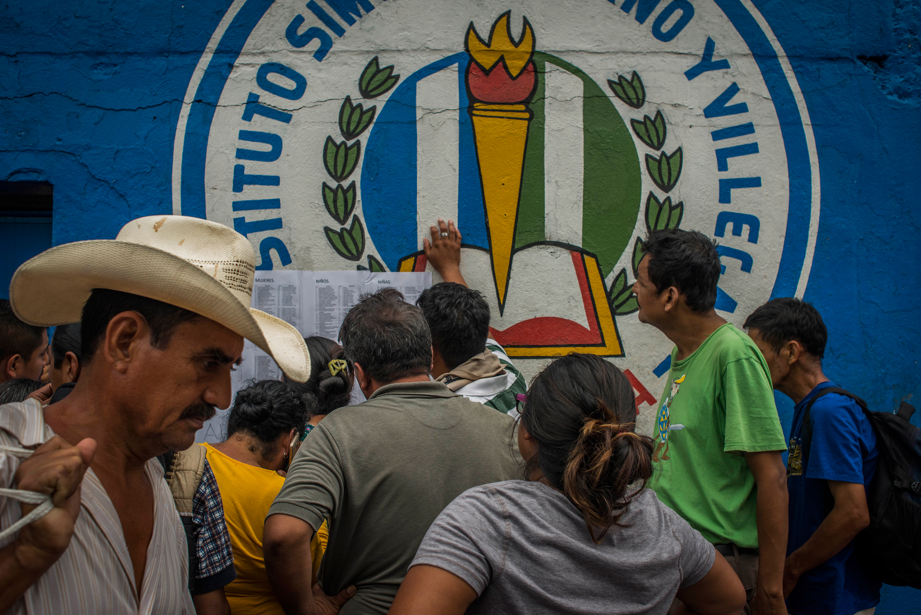 Residents of San Miguel Los Lotes look for relatives' names on a list of survivors at the entrance to a shelter in Escuintla on June 4. (Daniele Volpe)