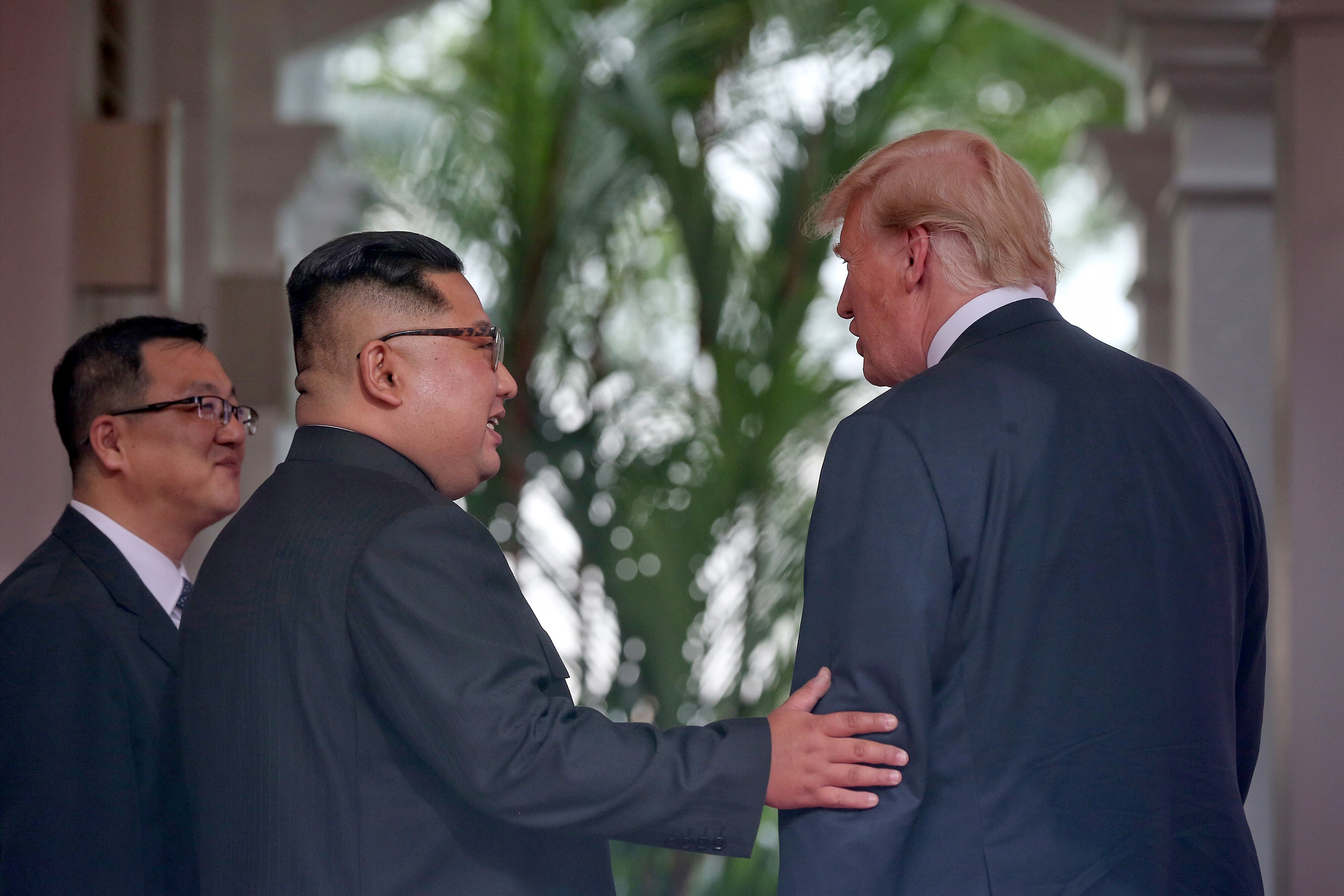 North Korean leader Kim Jong Un touches the arm of PresidentTrump shortly after meeting at their summit in Singapore on June 12, 2018. (Kevin Lim—The Straits Times/Getty Images)