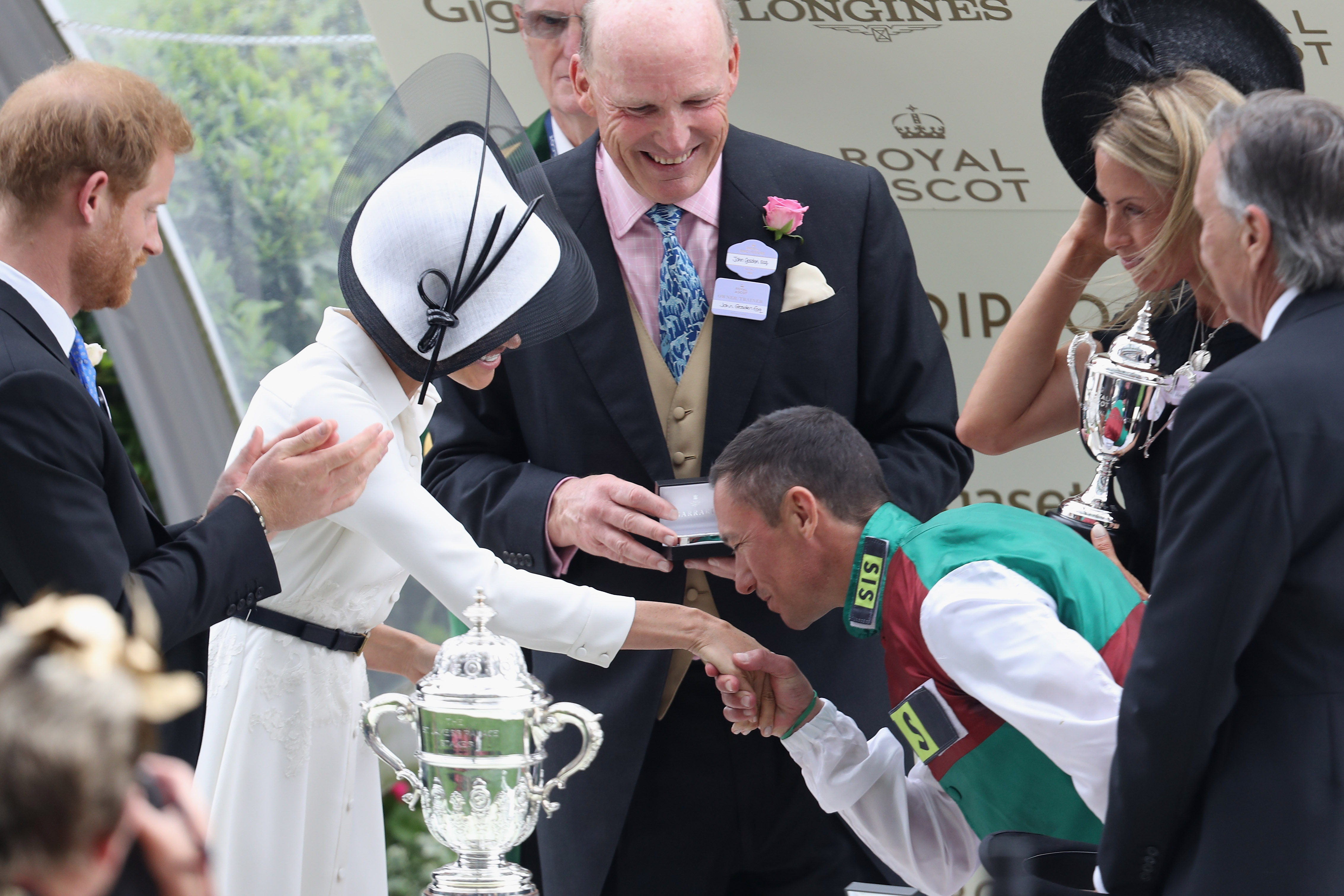 Meghan, Duchess of Sussex receives a kiss from Jockey Frankie Dettori as she and Prince Harry, Duke of Sussex present him with the trophy for winning the St James's Palace Stakes on Without Parole during Royal Ascot Day 1. (Chris Jackson—Getty Images)