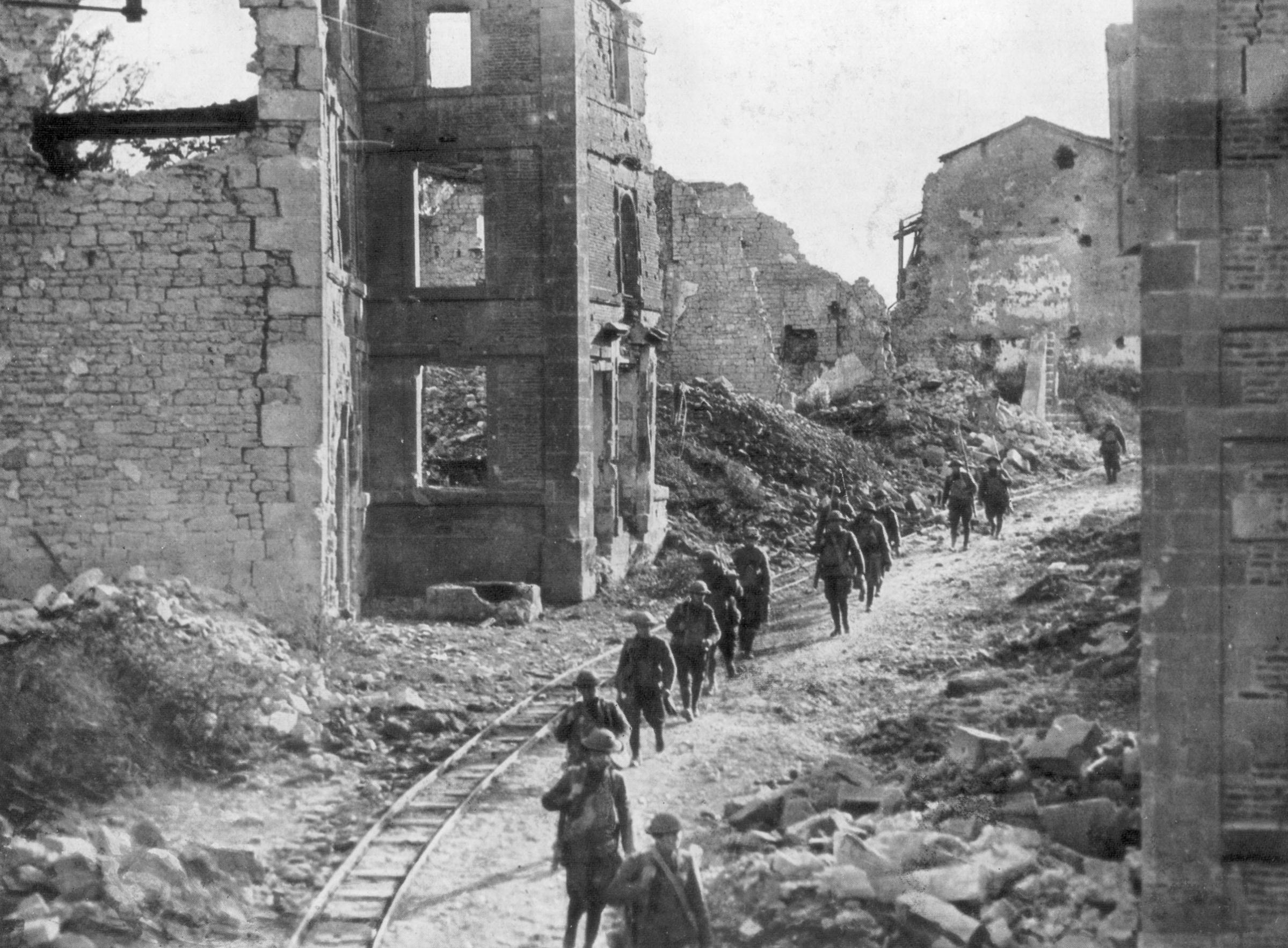 American soldiers passing through the ruins of Varennes, Meuse-Argonne Offensive, France, 1918.
