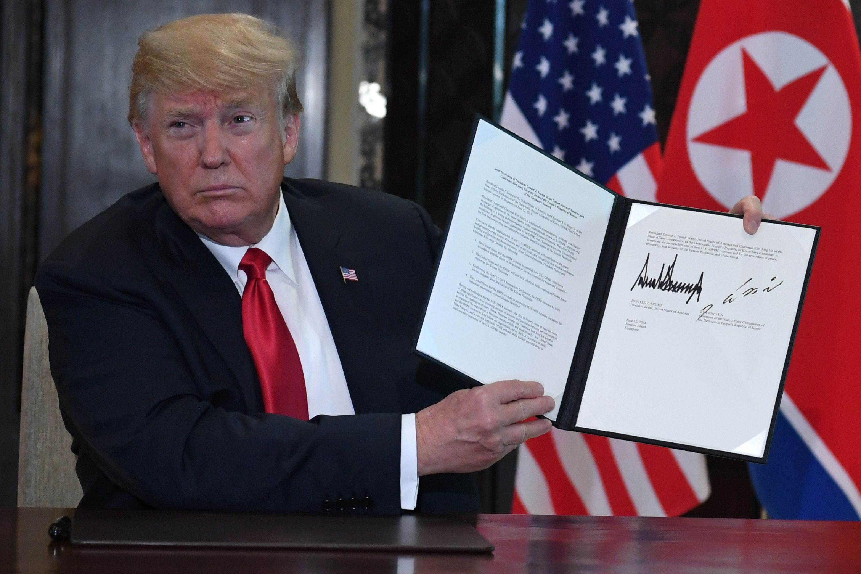 U.S. President Donald Trump holds up a document signed by him and North Korea's leader Kim Jong Un following their historic US-North Korea summit, at the Capella Hotel on Sentosa island in Singapore on June 12, 2018. (Saul Loeb—AFP/Getty Images)