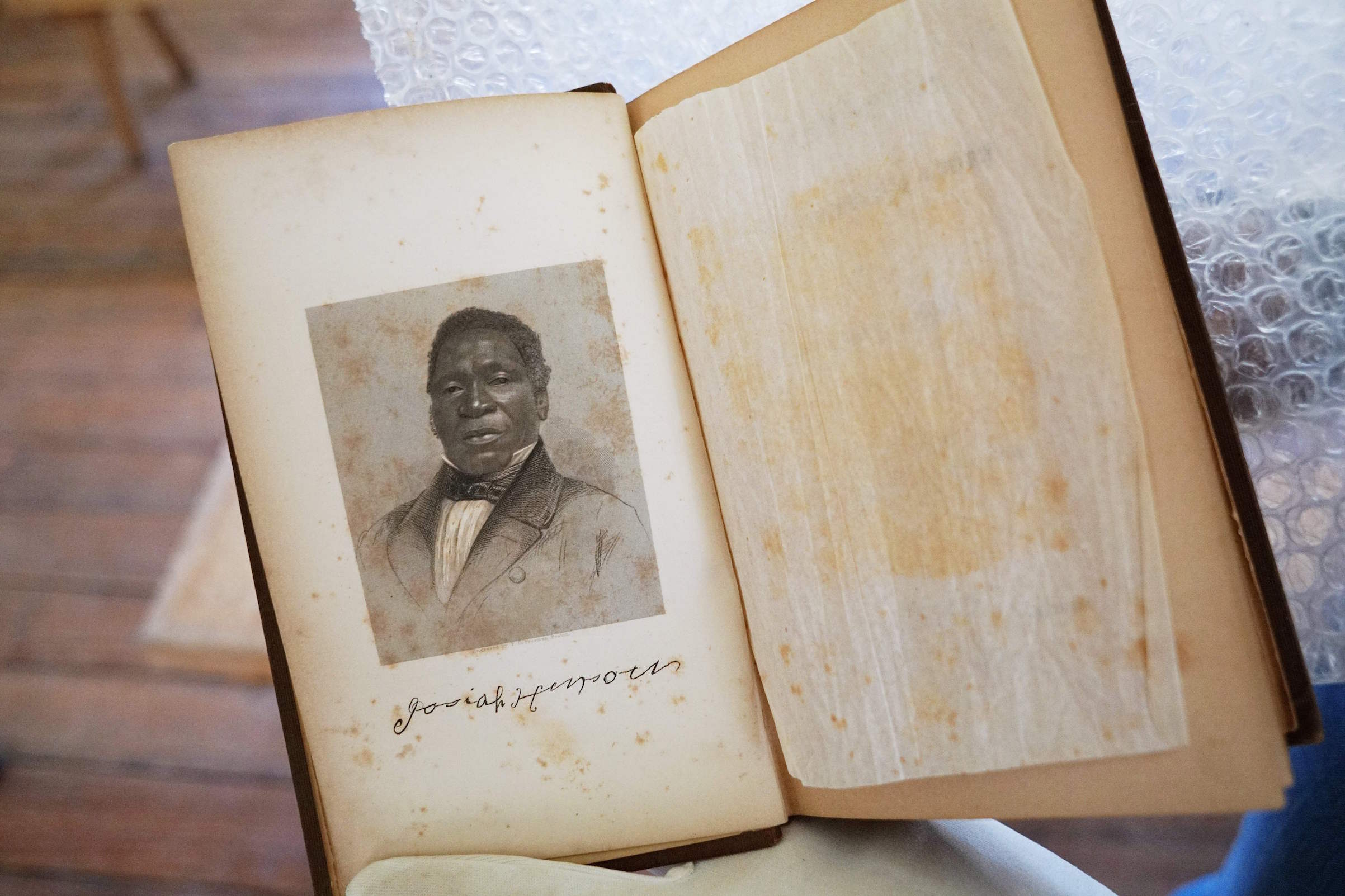 A photo taken on March 29, 2017 shows a portrait of Josiah Henson in a book he authored, at Josiah Henson Park in Bethesda, Md.
                      His life may have inspired the landmark novel "Uncle Tom's Cabin" but 150 years after the abolition of slavery in the US, Josiah Henson remains a controversial figure. (Mandel Ngan—AFP/Getty Images)