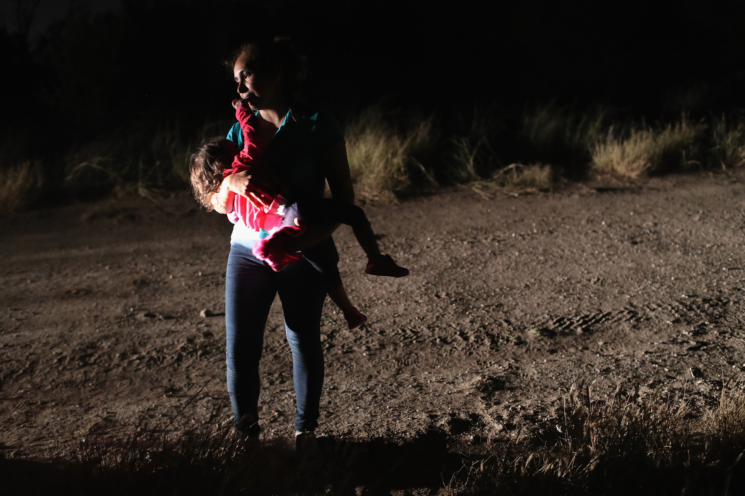 A Honduran mother holds her two-year-old daughter while being detained by U.S. Border Patrol agents near the U.S.-Mexico border on June 12, 2018 in McAllen, Texas. The asylum seekers were detained before being sent to a processing center for possible separation. Customs and Border Protection (CBP) is executing the Trump administration's "zero tolerance" policy towards undocumented immigrants. (John Moore—Getty Images)
