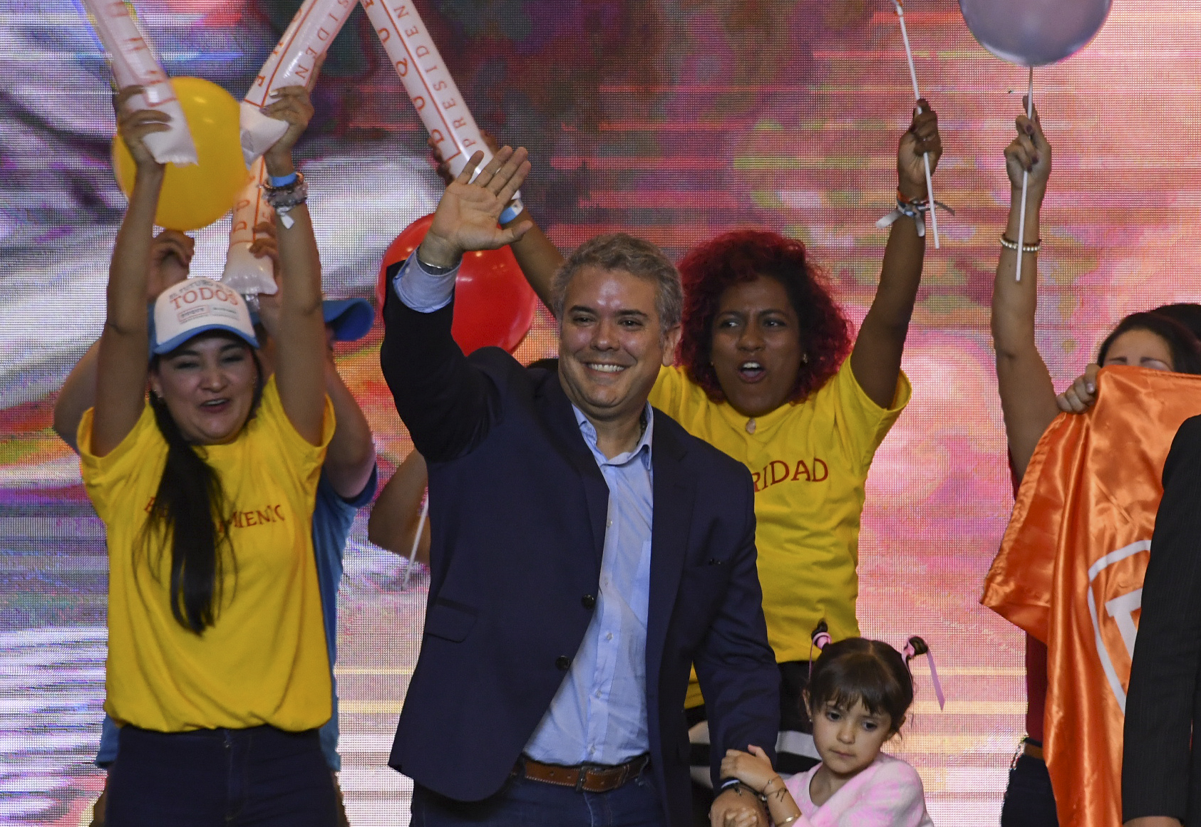 Colombian presidential candidate Ivan Duque, for the Democratic Centre party, holds his daughter's hand, as he waves to supporters in Bogota, after winning the first round of the Colombian presidential election on May 27, 2018. (Luis Acosta – AFP/Getty Images)