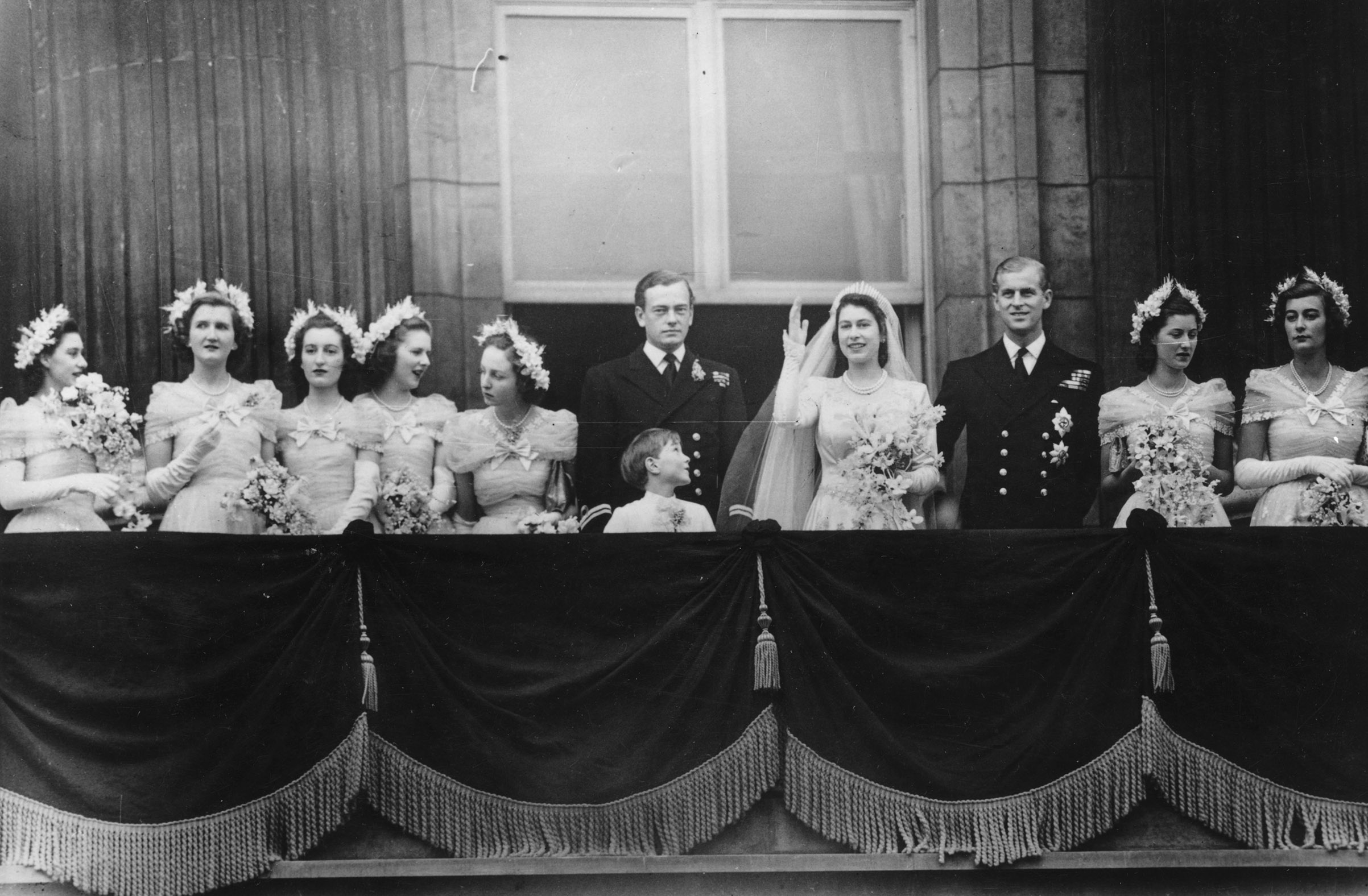 20th November 1947: The royal group on the balcony of Buckingham Palace after returning from the wedding ceremony between Princess Elizabeth and the Duke of Edinburgh at Westminster Abbey. (left to right) Princess Margaret (1930 - 2002), Margaret Elphinstone, Diana Bowes-Lyon, Lady Caroline Montague Douglas-Scott, Lady Elizabeth Lambert, the Marquis of Milford-Haven, Prince William, the bride and groom, Lady Mary Cambridge and Lady Pamela Mountbatten (Topical Press Agency/Getty Images)