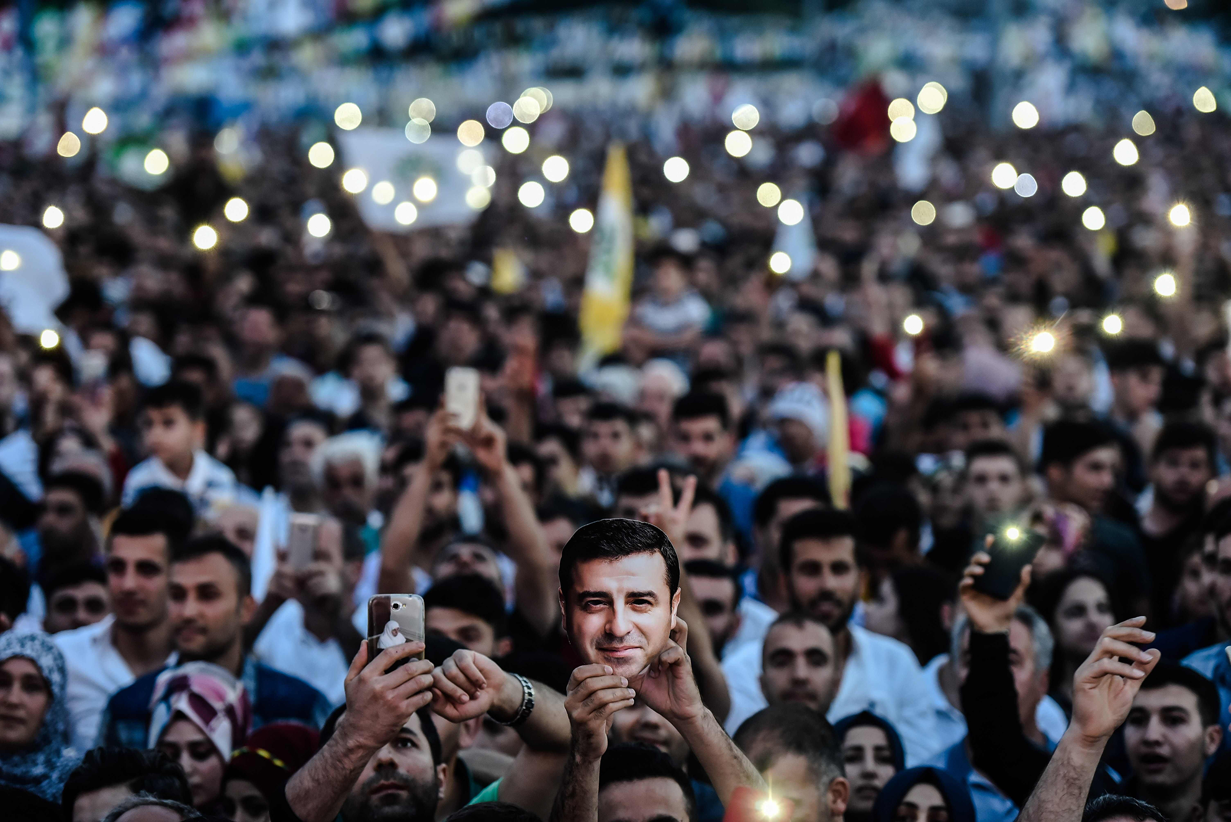 Supporters of imprisoned Selahattin Demirtas, Presidential candidate of People's Democratic Party (HDP), hold HDP flags with picture of of Demirtas during an election campaign office in Istanbul on June 17, 2018. (Yasin Akgul—AFP/Getty Images)