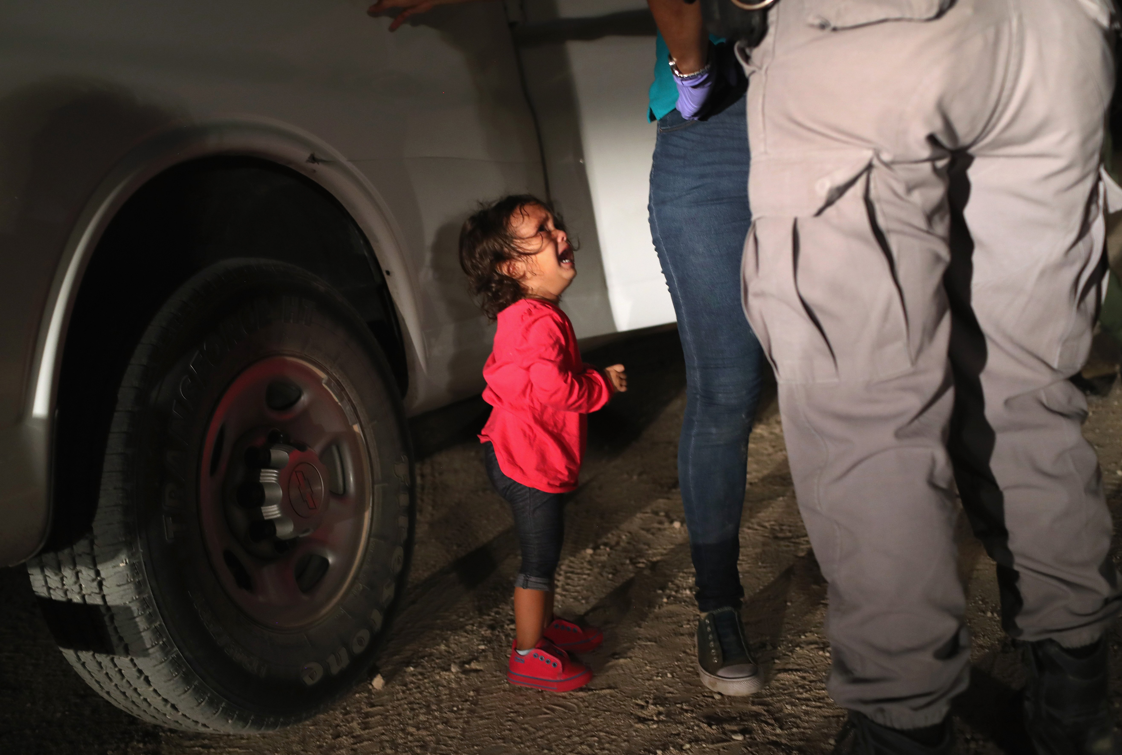 A two-year-old Honduran asylum seeker cries as her mother is searched and detained near the U.S.-Mexico border in McAllen, Texas on June 12, 2018. (John Moore—Getty Images)