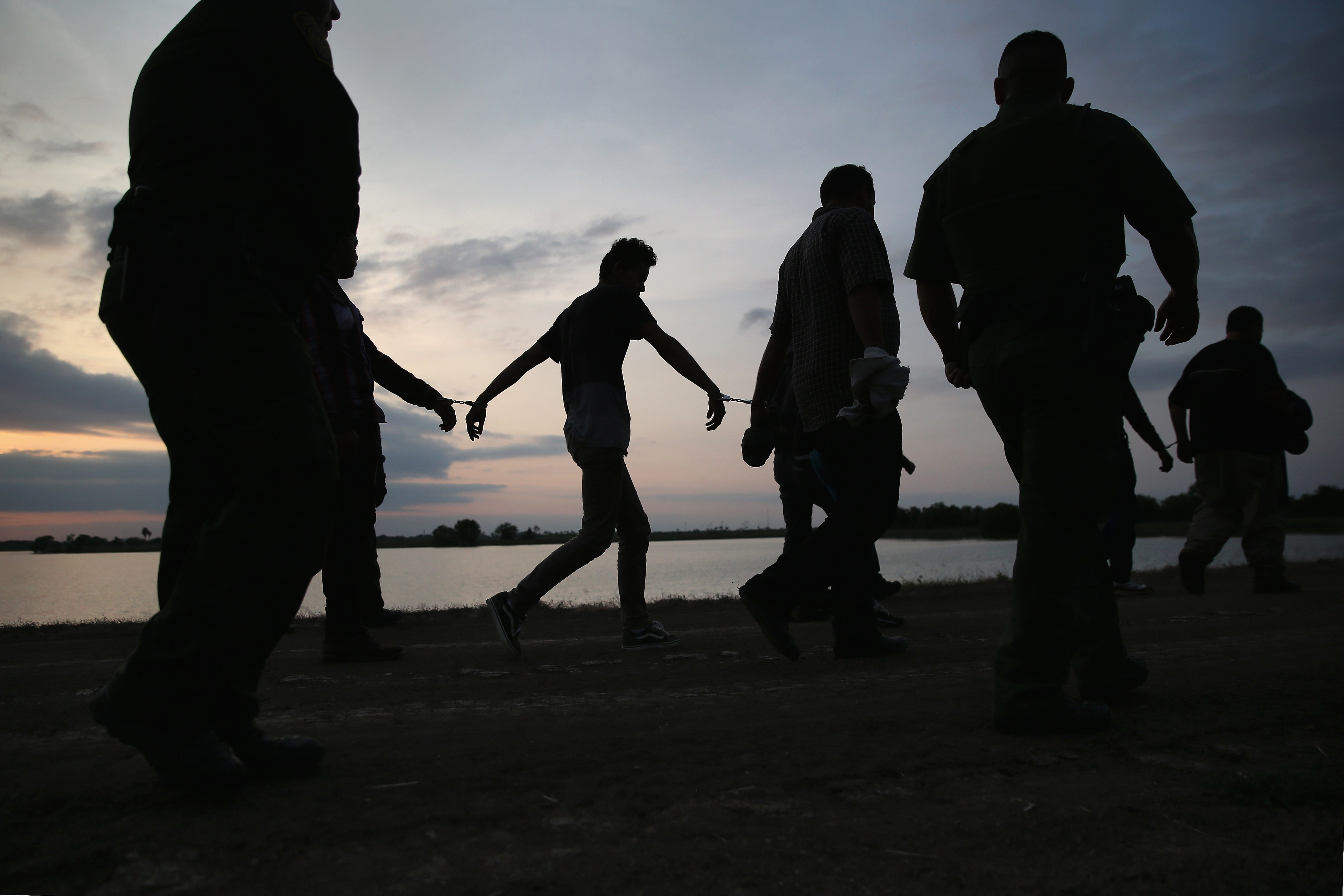 Undocumented immigrants are led after being caught and handcuffed by Border Patrol agents near the U.S.-Mexico border in Weslaco, Texas on April 13, 2016. (John Moore—Getty Images)