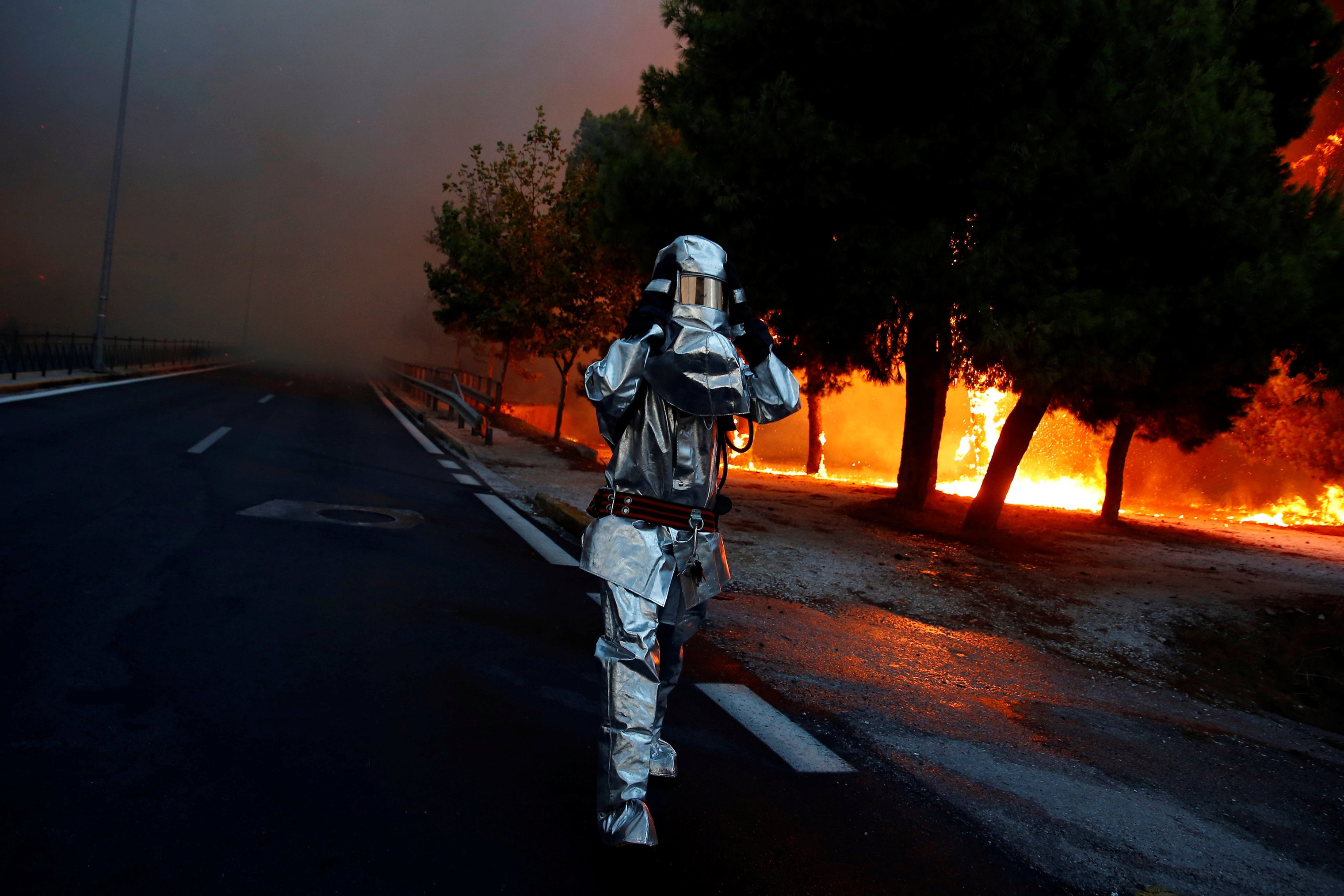 A firefighter wears a flame resistant uniform as wildfire burns in the town of Rafina, near Athens on July 23, 2018. (Costas Baltas—Reuters)