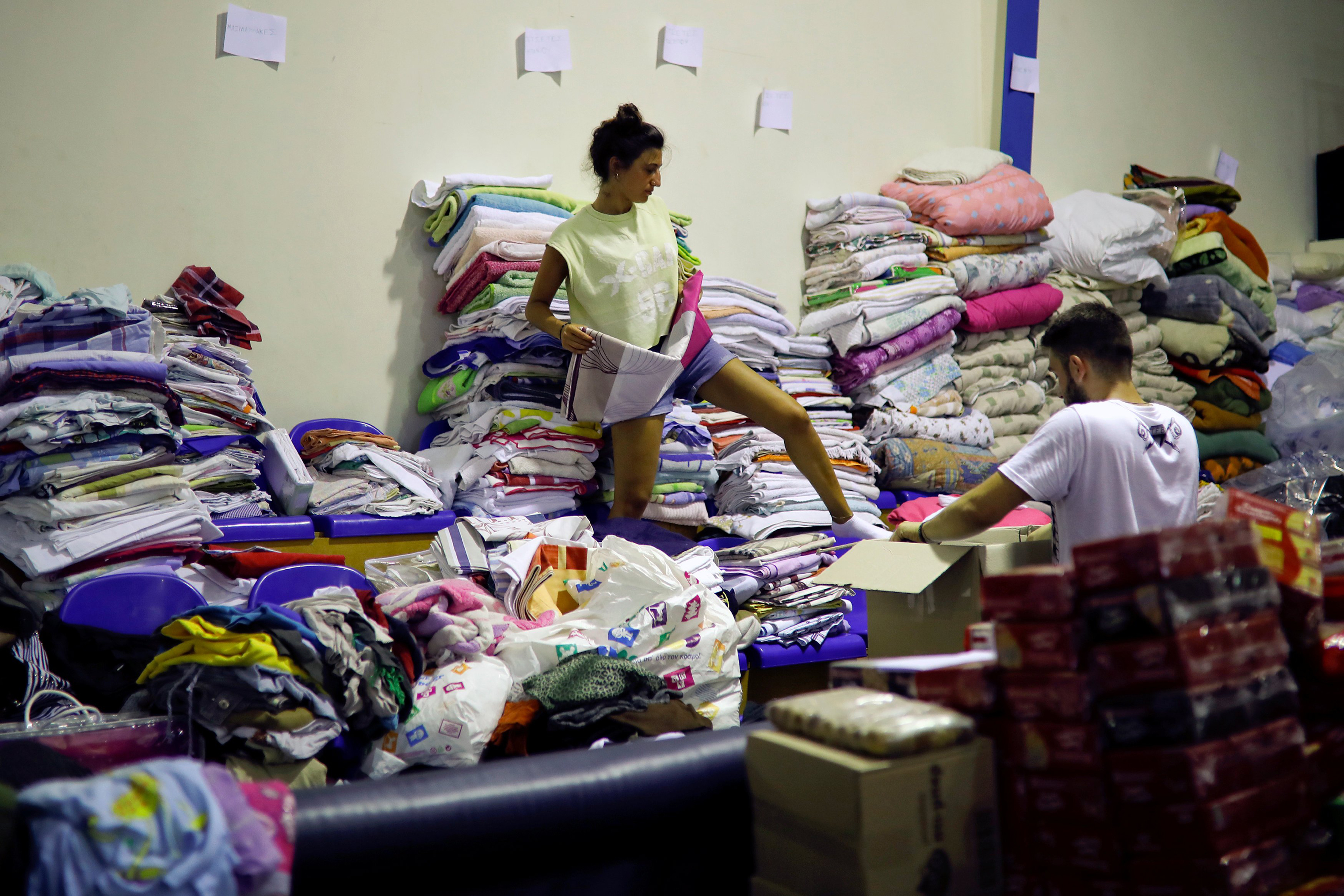 A volunteer arranges clothes for residents in Nea Makri, near Athens on July 25, 2018. (Alkis Konstantinidis—Reuters)