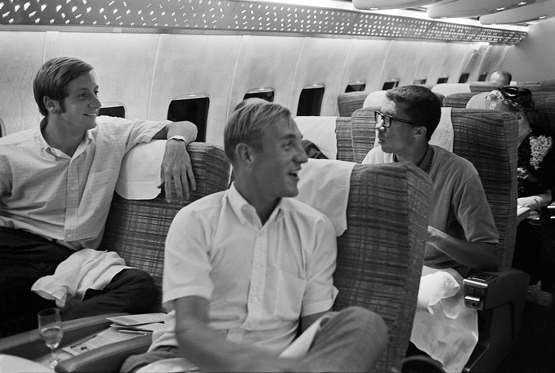 American Davis Cup team members Bob Lutz (left), Stan Smith (center) and Arthur Ashe aboard a flight to Las Vegas for Davis Cup exhibition play, September 10, 1968.  Earlier in the day, Smith and Lutz won their first Grand Slam doubles title at the US Open, defeating Davis Cup teammate Ashe and his partner, Andrés Gimeno, in the final. Photo by John G. Zimmerman.