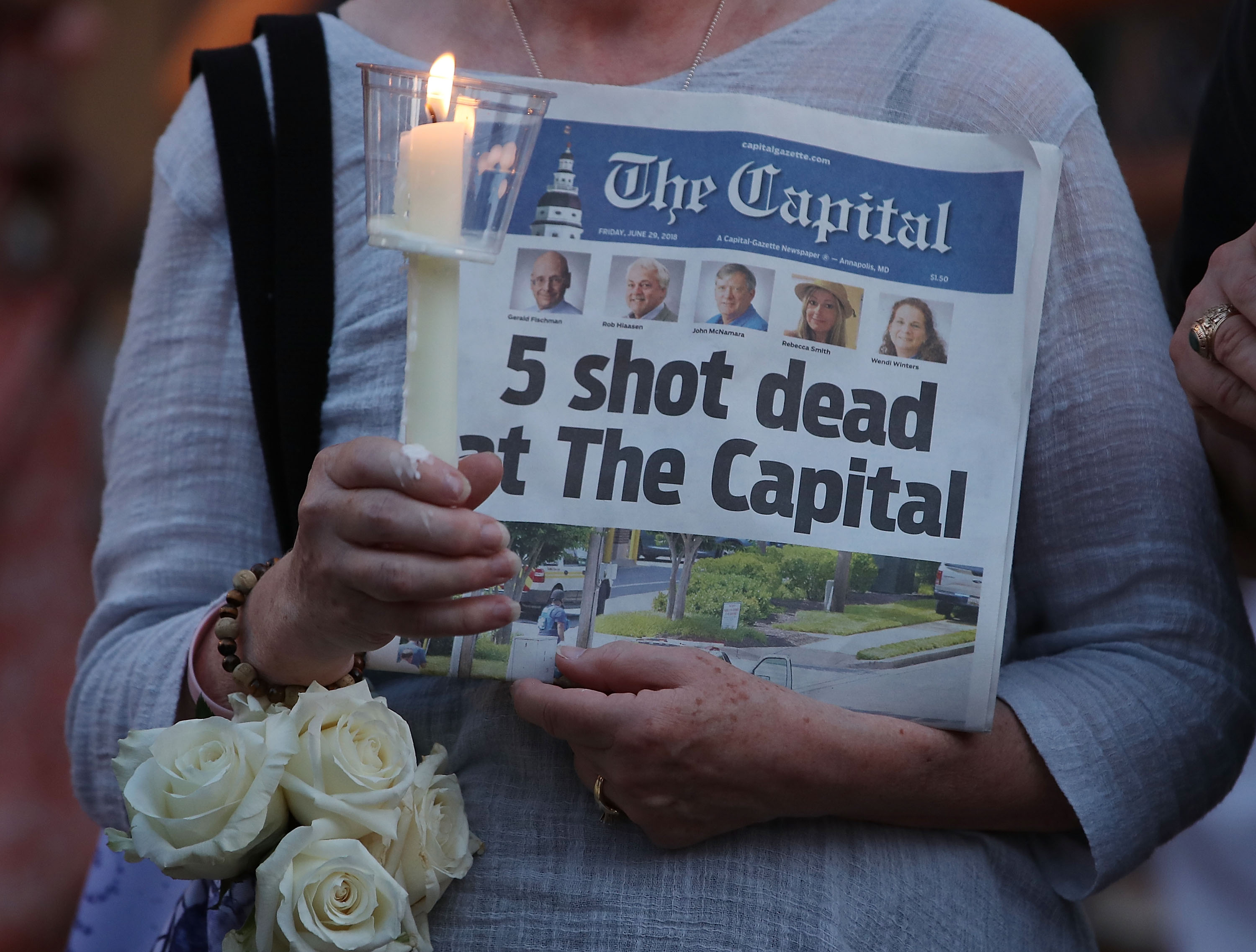 A women holds today's edition of the Capital Gazette newspaper during a candlelight vigil to honor the 5 people who were shot and killed yesterday, on June 29, 2018 in Annapolis, Maryland. (Mark Wilson—Getty Images)