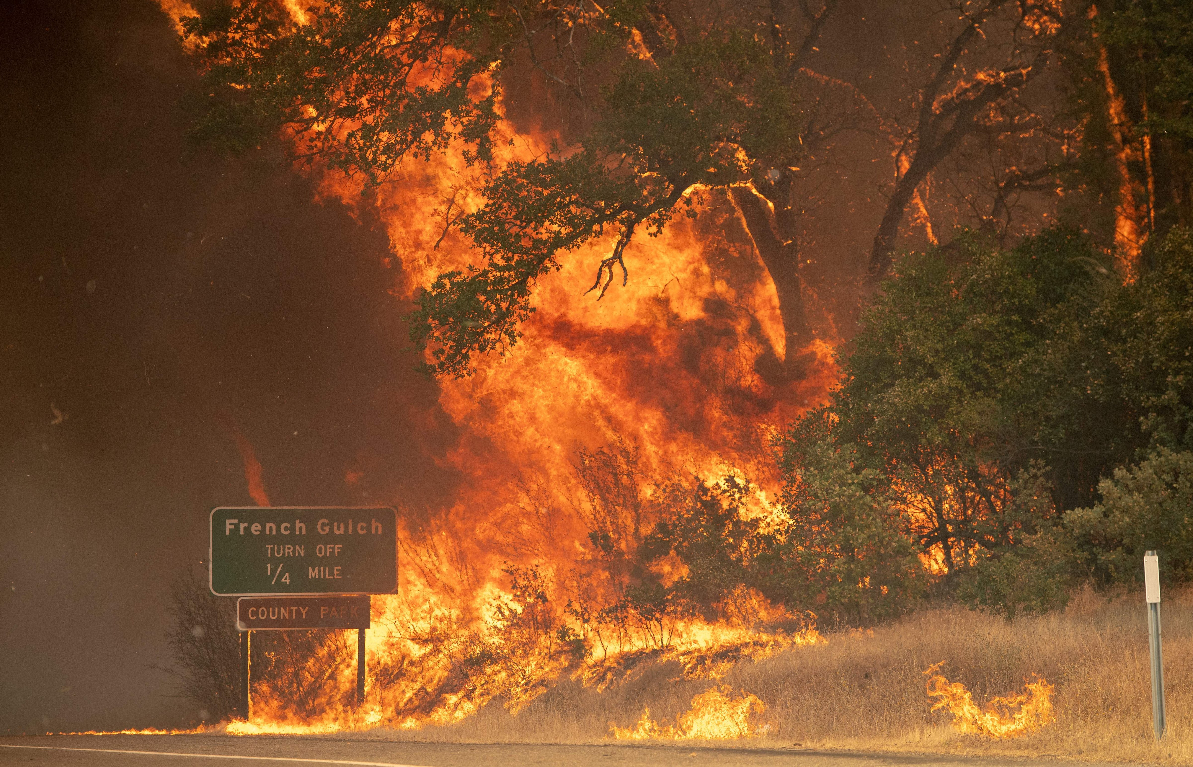 A power pole leans over a burned property as the sky turns a deep orange during the Carr fire near Redding, California on July 27, 2018. (JOSH EDELSON—AFP/Getty Images)