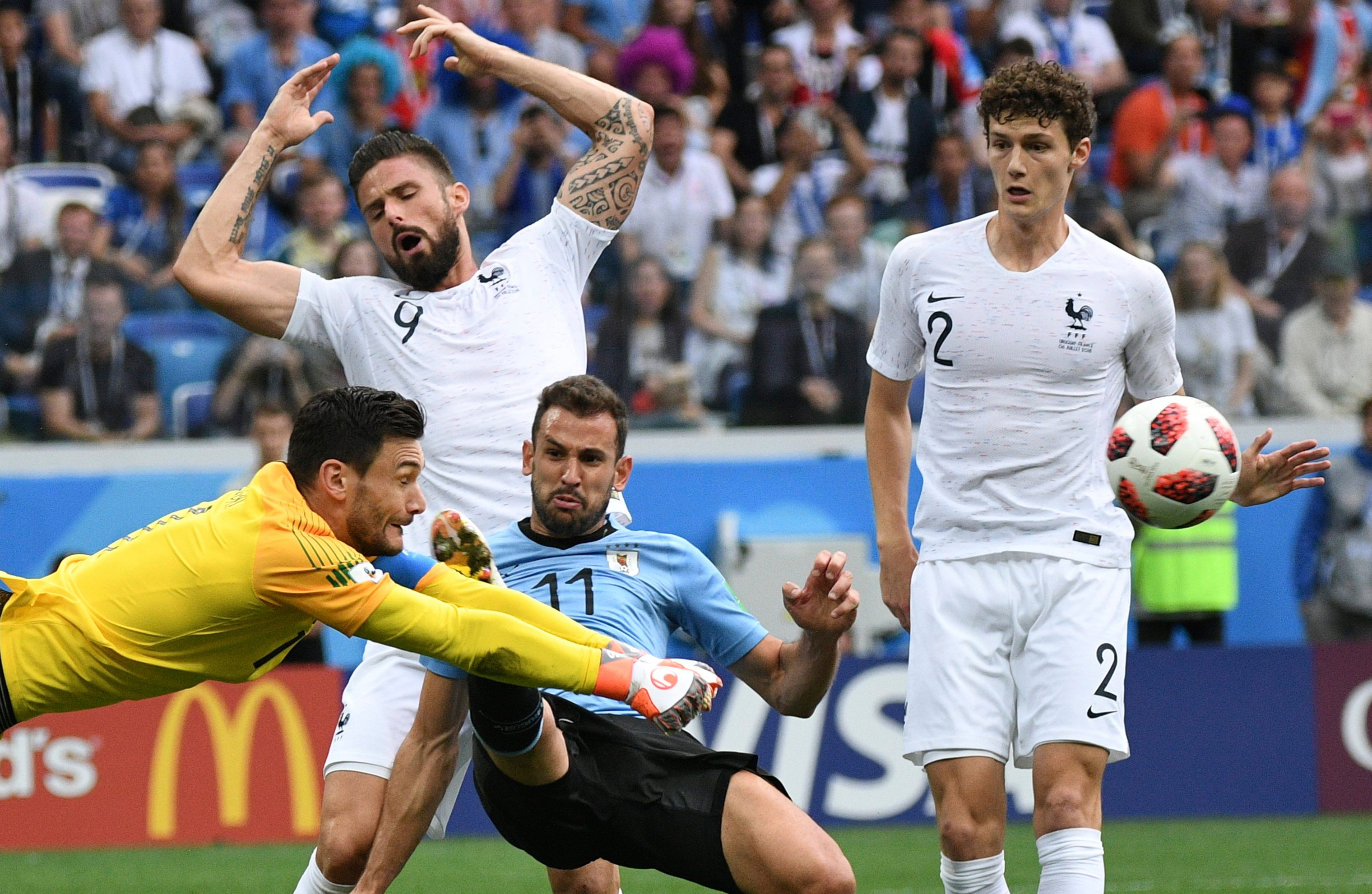 France's goalkeeper Hugo Lloris, left, makes a save during the quarterfinal soccer game between Uruguay and France on July 6, 2018. (Grigoriy Sokolov—Sputnik/AP)