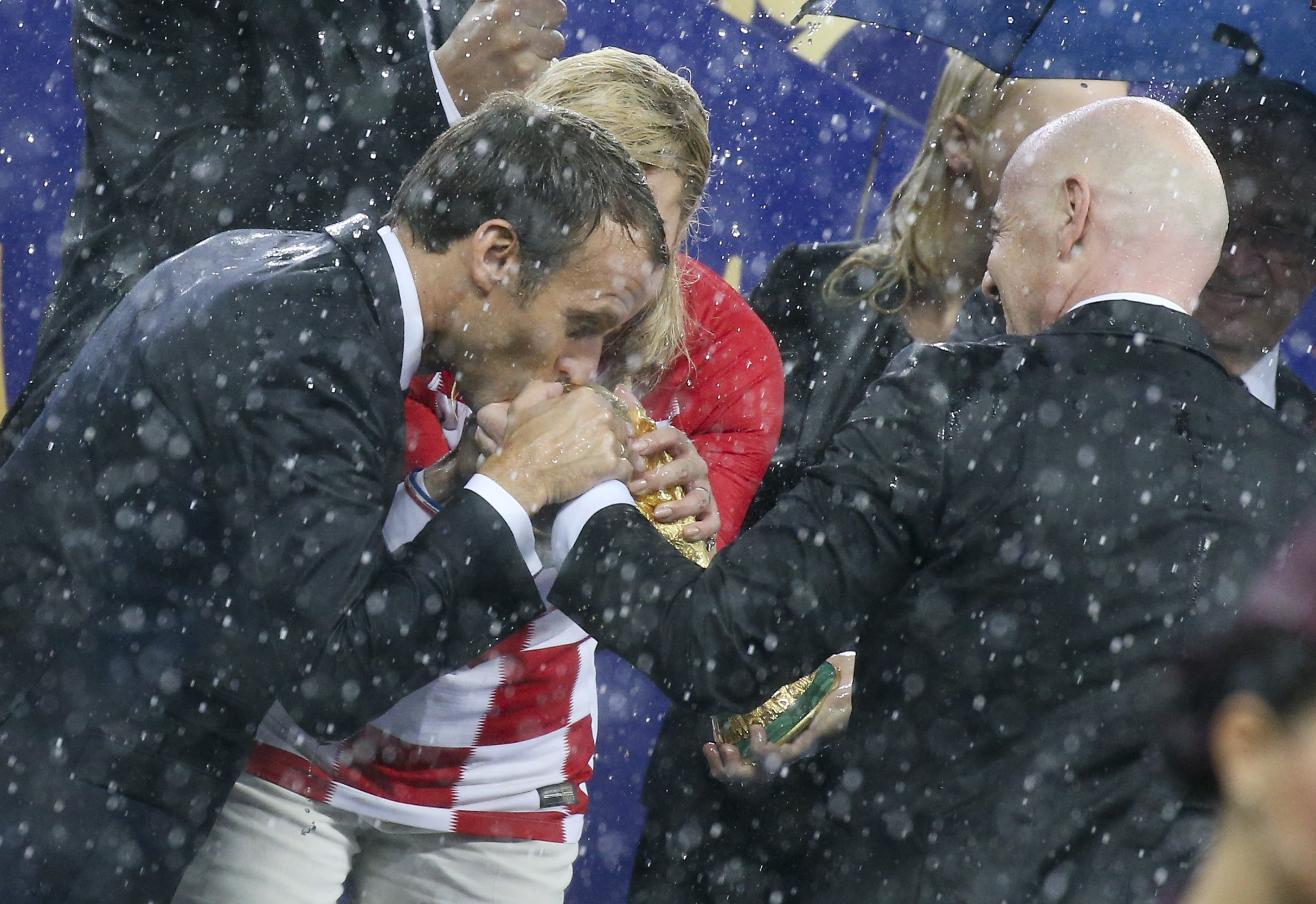 President of France Emmanuel Macron and President of Croatia Kolinda Grabar-Kitarovic want to kiss the World Cup held by FIFA President Gianni Infantino during the trophy ceremony following the 2018 FIFA World Cup Russia Final between France and Croatia at Luzhniki Stadium on July 15, 2018 in Moscow, Russia. (Photo by Jean Catuffe/Getty Images) (Jean Catuffe—Getty Images)