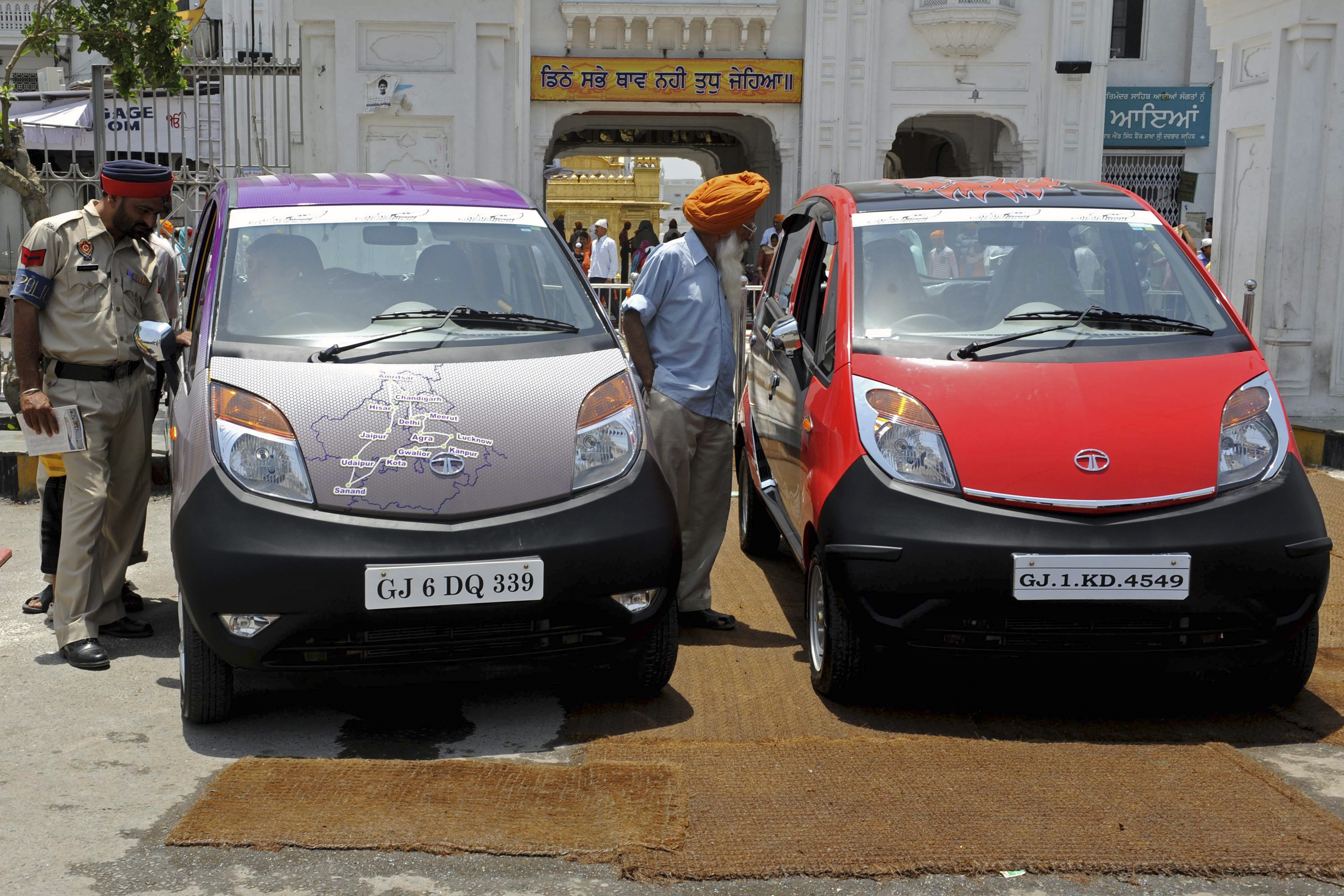 Bystanders take a closer look at Tata's Nano cars, billed as the 