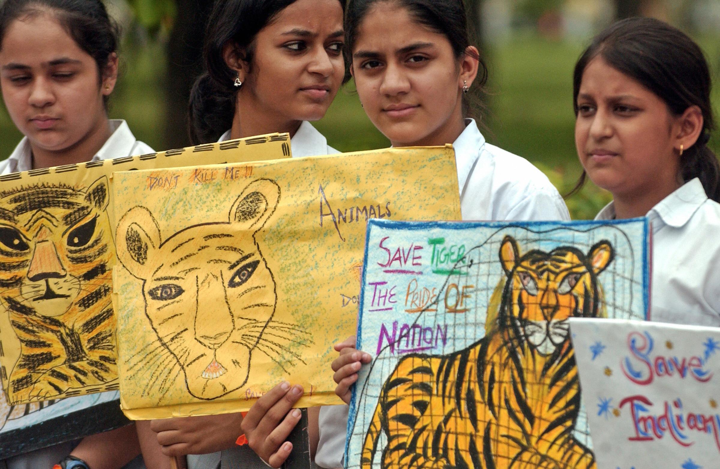 Indian school children hold placards dur