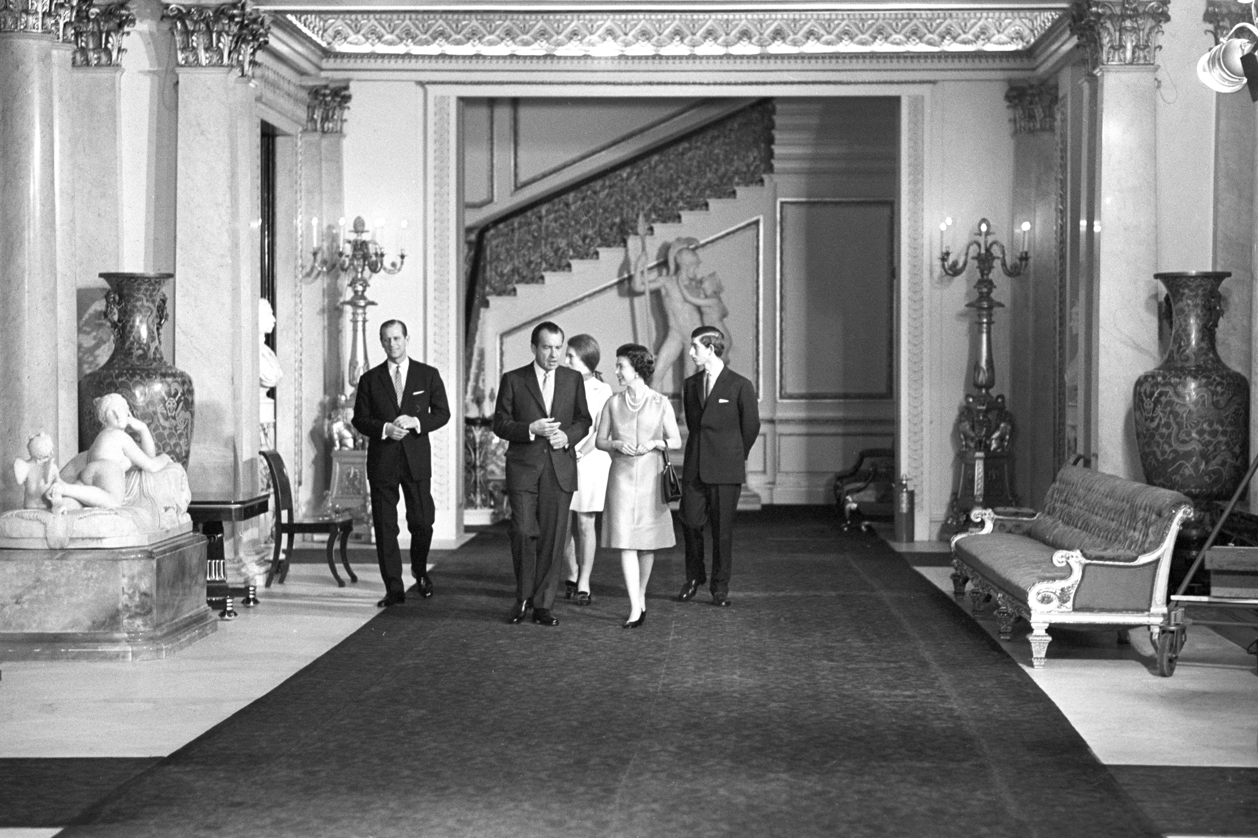 Queen Elizabeth II with American President Richard Nixon, as they walk through the corridors of Buckingham Palace on February 25, 1969. With them are the Duke of Edinburgh and Prince of Wales. (PA Images via Getty Images)
