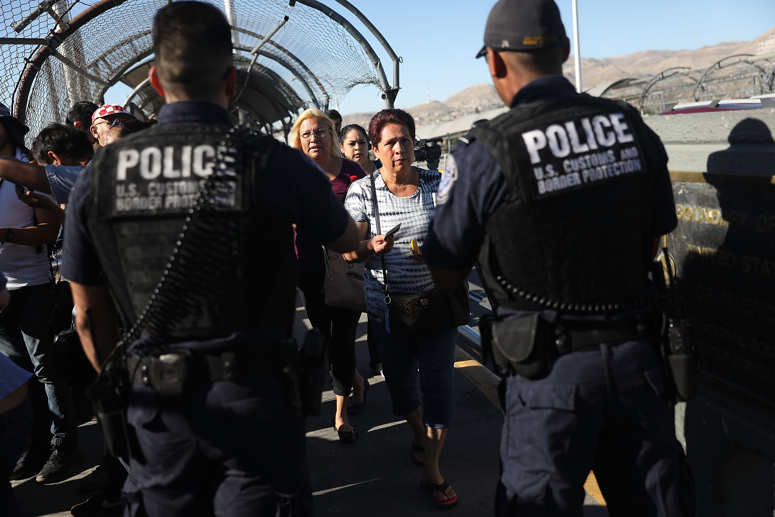 U.S. Border Patrol agents check passports at the Paso Del Norte Port of Entry, where the U.S. and Mexico border meet, as people walk across the bridge to enter the United States on June 20, 2018 in El Paso, Texas. (Joe Raedle—Getty Images)