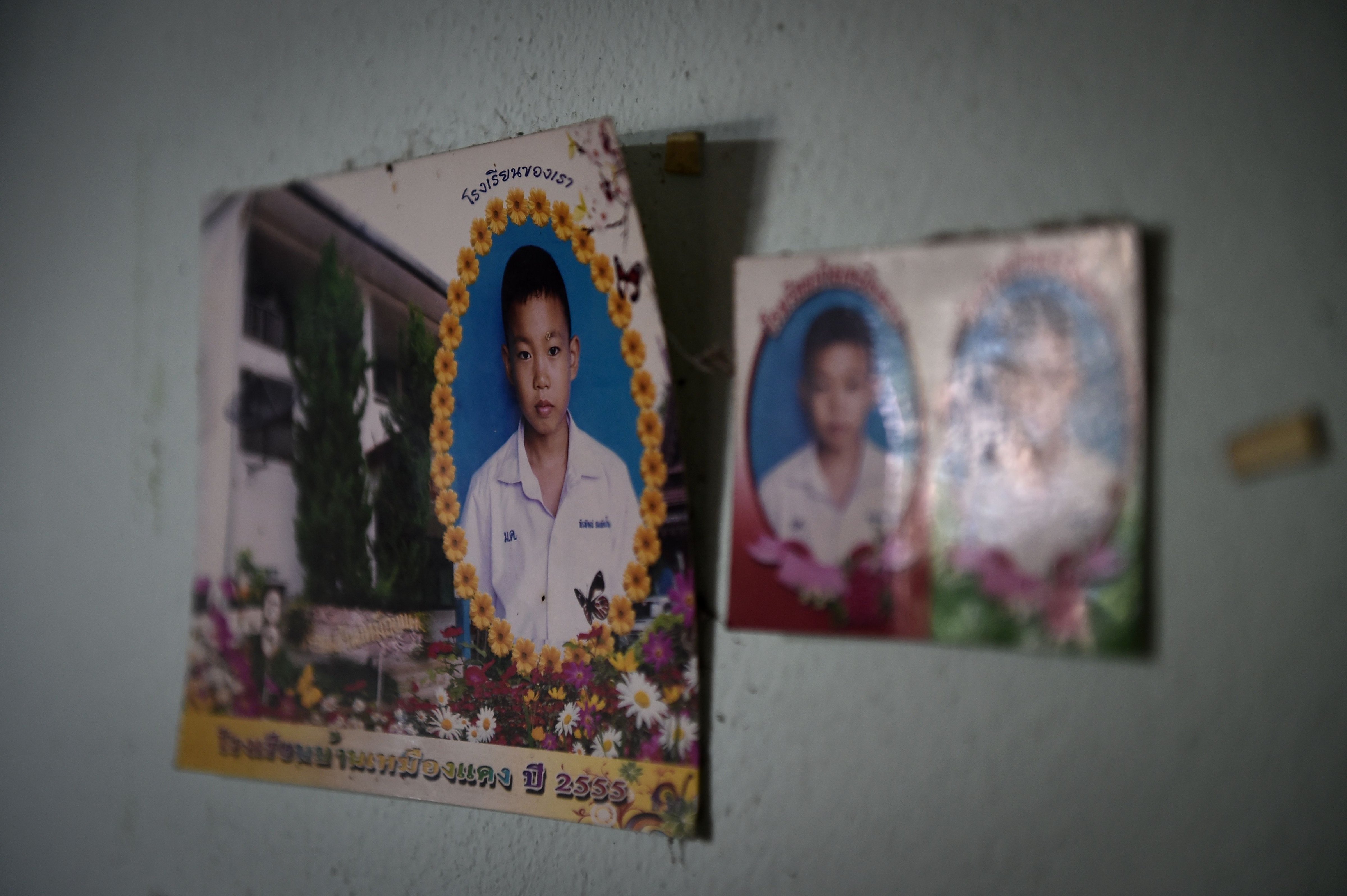 Photographs of Pheeraphat 'Night' Sompiengjai, one of the members of a Thai youth football team currently trapped at the Tham Luang cave, are seen on a wall at his home in Mae Sai on July 4, 2018. (Lillian Suwanrumpha—AFP/Getty Images)