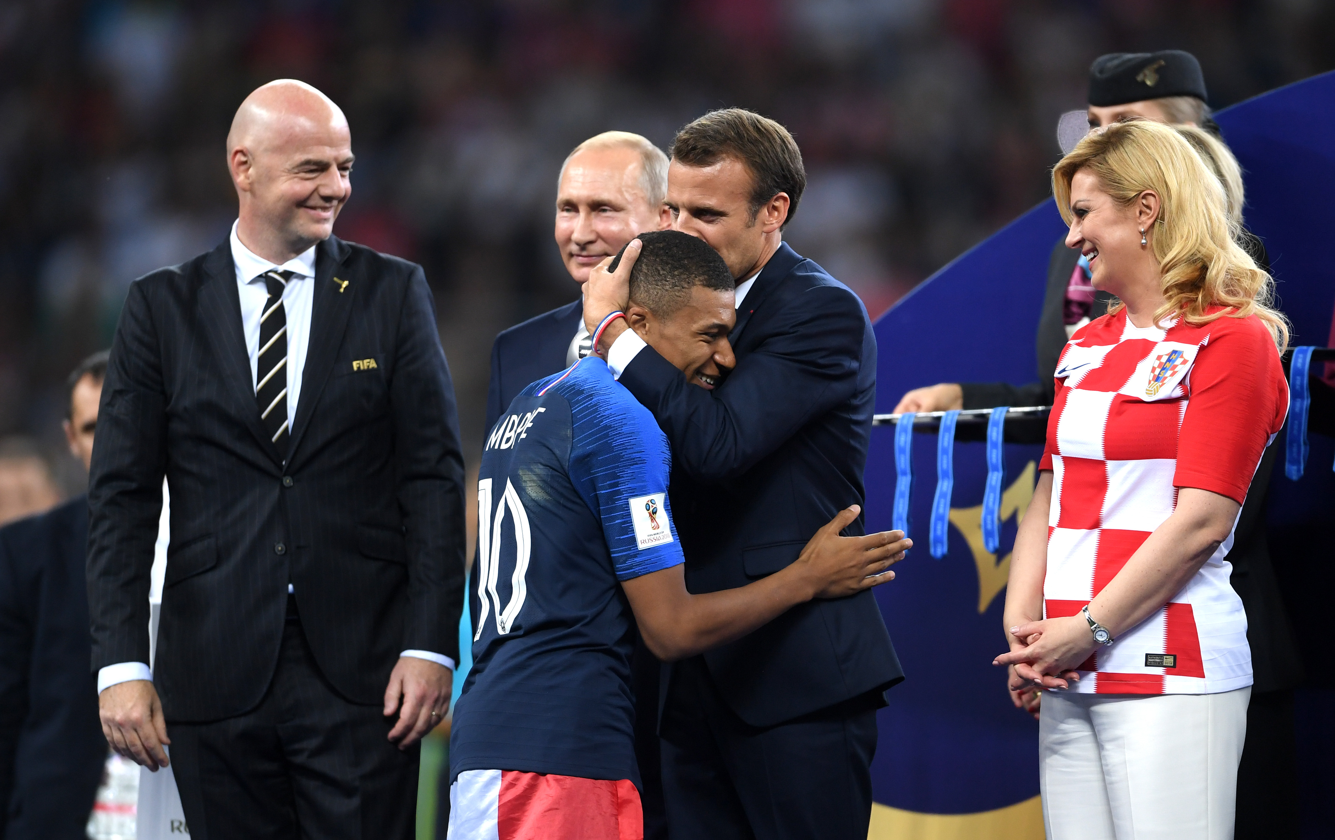 French President Emmanuel Macron awards Kylian Mbappe of France with the FIFA Young Player Award as President of Russia Vladimir Putin and President of Croatia, Kolinda Grabar Kitarovic look on following the 2018 FIFA World Cup Final between France and Croatia at Luzhniki Stadium on July 15, 2018 in Moscow, Russia. (Photo by Laurence Griffiths/Getty Images) (Laurence Griffiths—Getty Images)