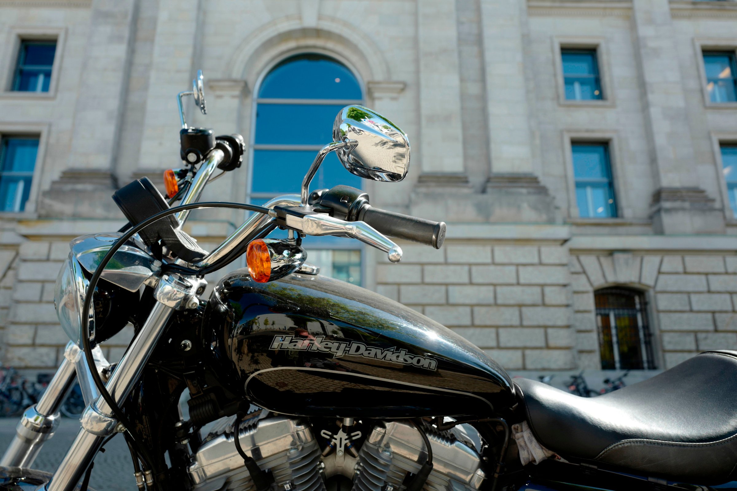 A Harley-Davidson motorbike is parked outside a European building