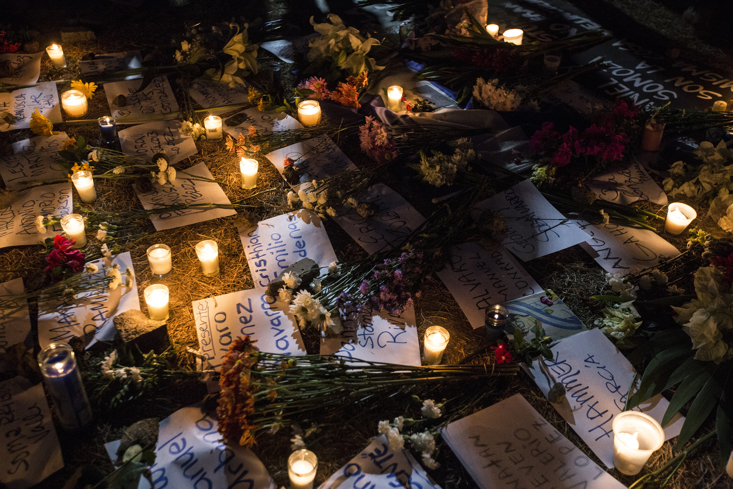 Flowers and candles surround papers written with the names of victims, who were killed during the protests, on April 25. (Fred Ramos—El Faro)