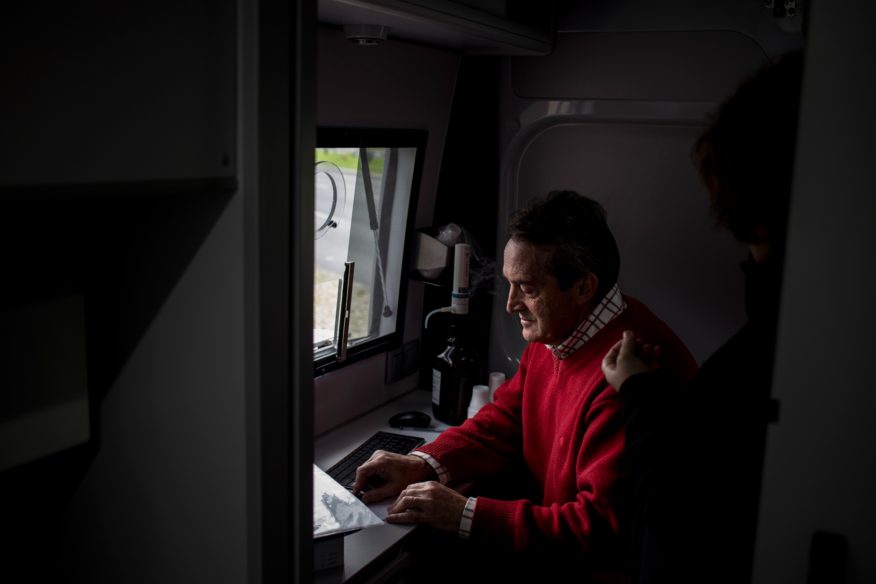 João, a 60-year old nurse, searches for a patient’s doses at a state sponsored mobile methadone clinic in Lisbon, February 9, 2017. It is operated by the Ares do Pinhal Association, and has existed since the Casal Ventoso neighborhood was demolished. The two vans administer methadone maintenance therapy to more than 1,200 people every day. Opioid users who receive this treatment on the street are healthier and safer than those who do not. (Gonçalo Fonseca)