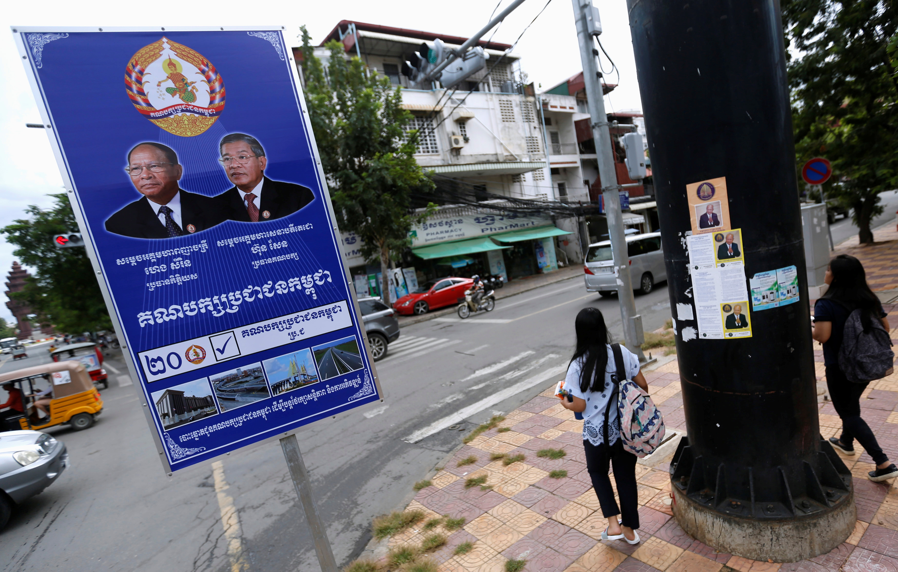 Posters of the Cambodian People's Party (CPP) and FUNCINPEC Party are seen along a street in Phnom Penh