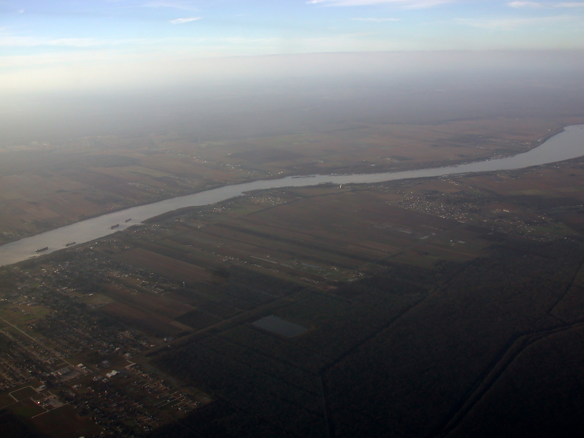 The Mississippi River, seen here north of New Orleans, feeds into the Port of South Louisiana, the largest port in the U.S. Port workers here have higher average starting salaries than workers in the tourism sector (Stacy Kranitz)