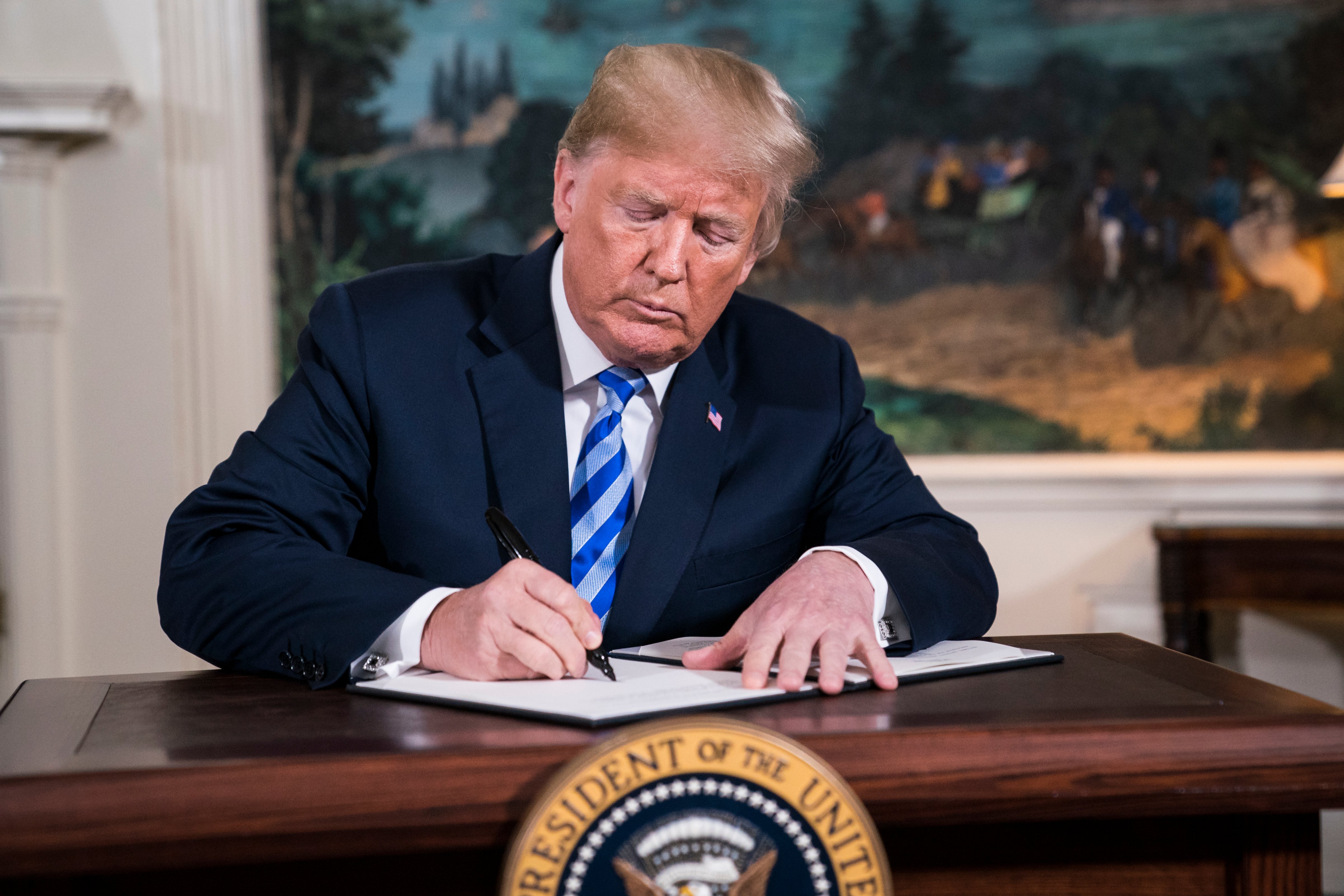 President Donald J. Trump signs a National Security Presidential Memorandum as he announces the withdrawal of the United States from the Iran nuclear deal on May 8, 2018. (The Washington Post—The Washington Post/Getty Images)